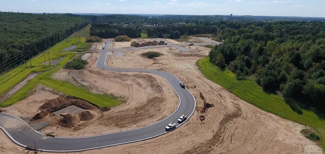 An aerial view of a curvy road in the middle of a forest.