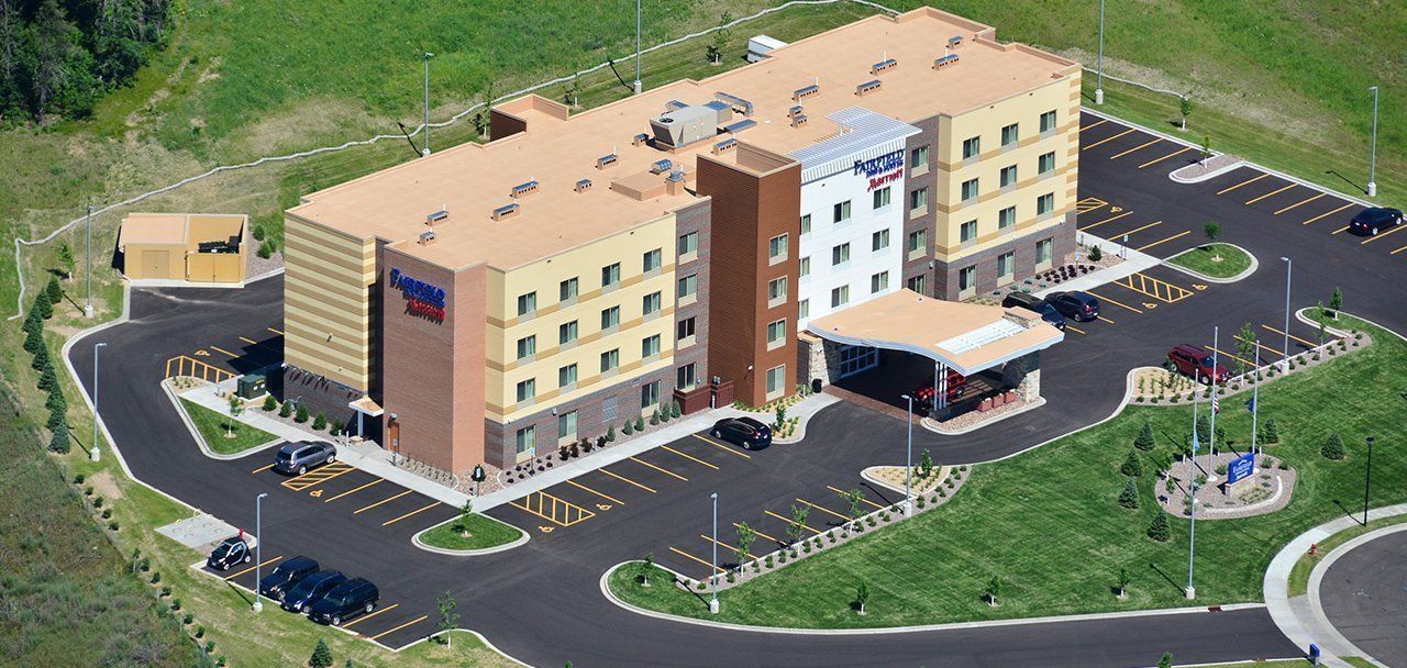 An aerial view of a large hotel with a parking lot in front of it