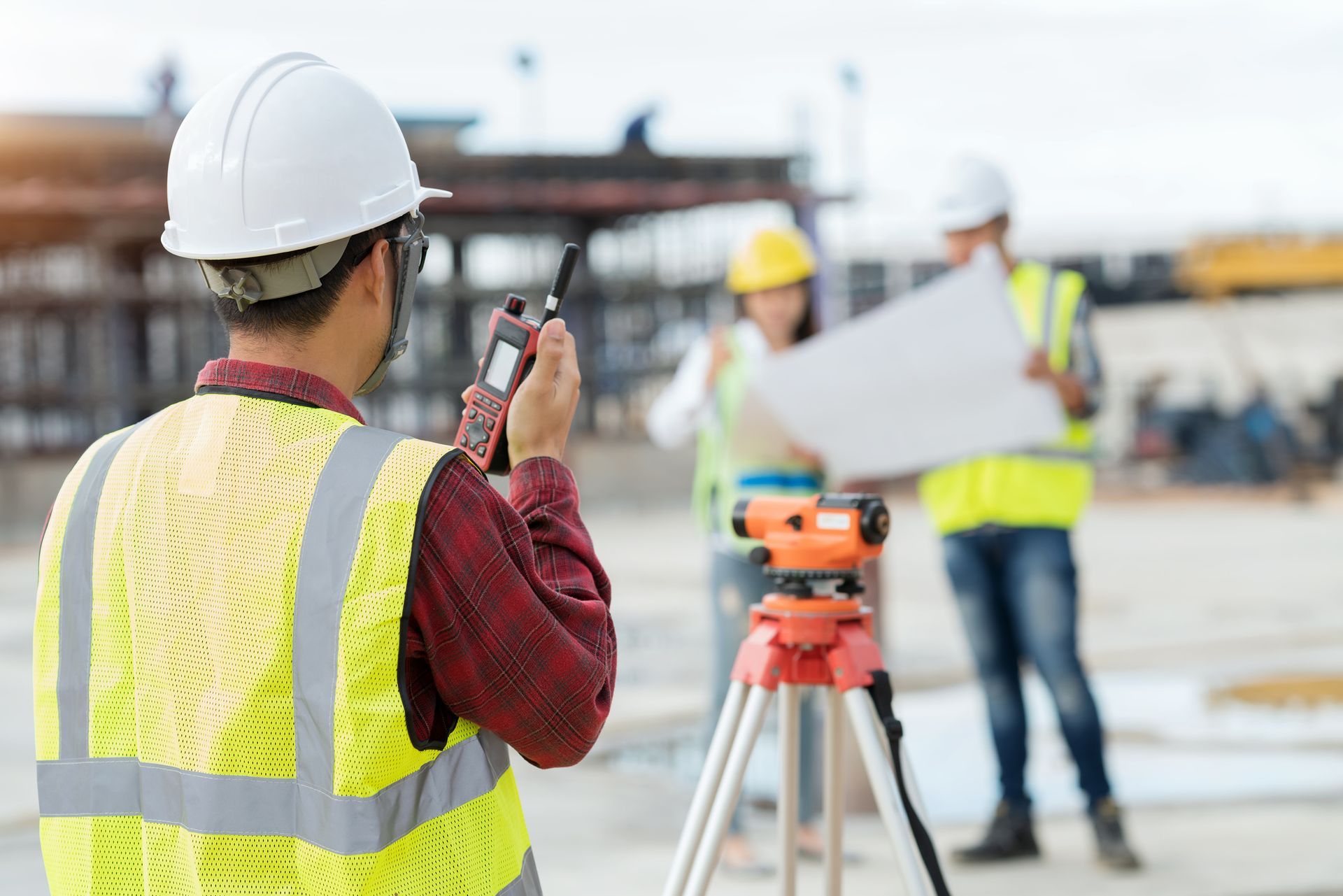 Engineer measuring site levels with survey equipment, promoting expert land surveyors services.