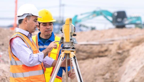Engineer measuring site levels with survey equipment, promoting expert land surveyors services.