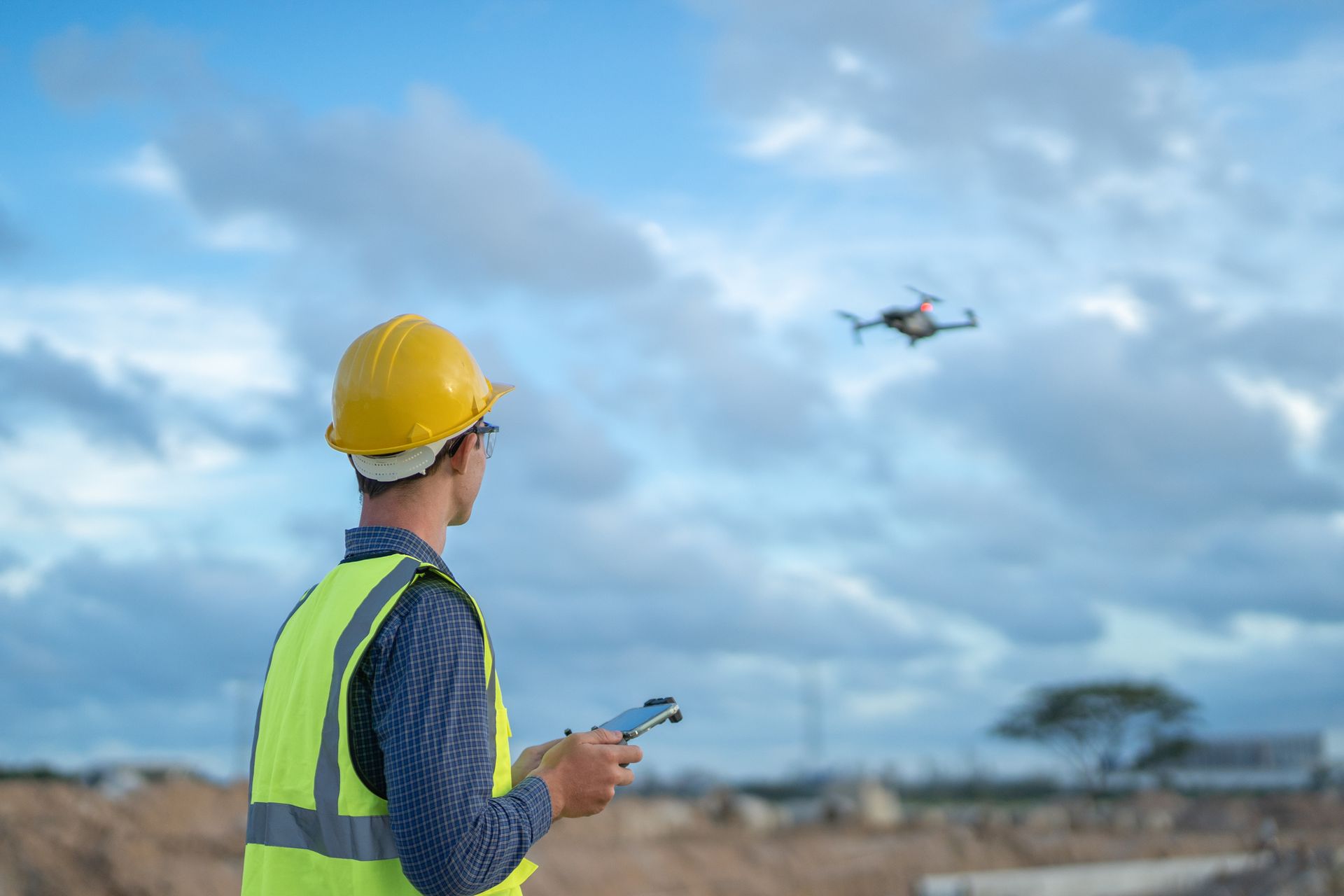 Surveyor and drone survey land for construction and soil development work.