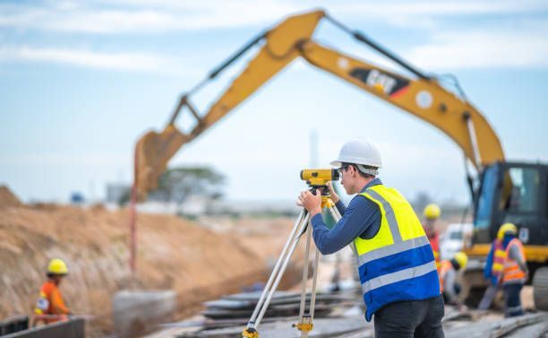 Engineer measuring site levels with survey equipment, promoting expert land surveyors services.