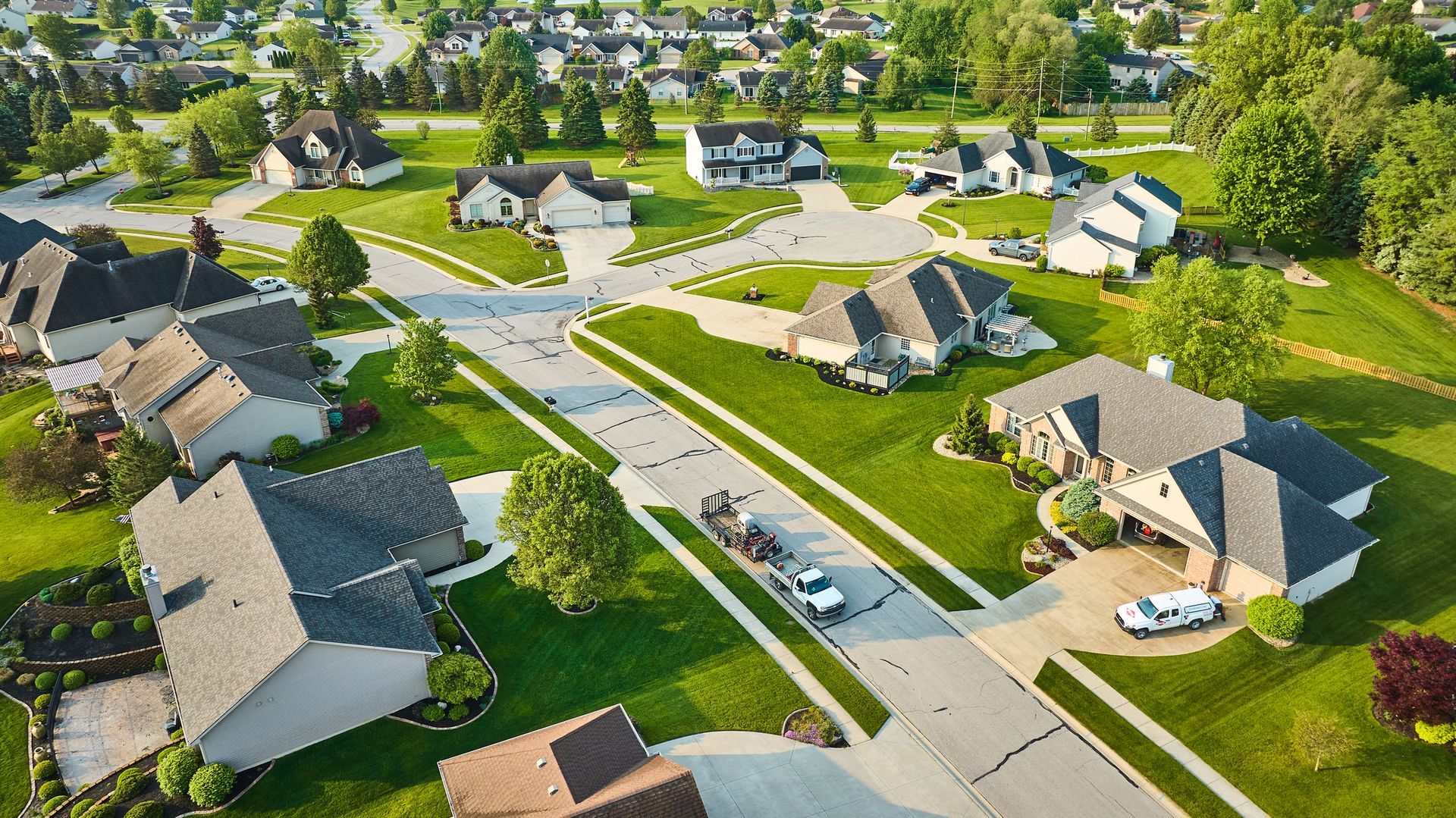 An aerial view of a residential neighborhood with lots of houses and trees.