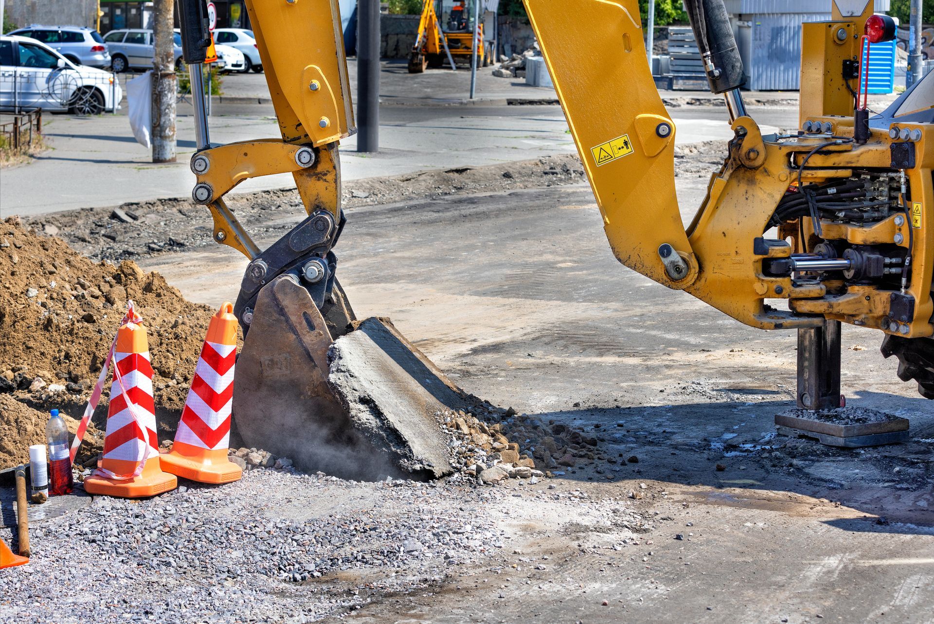 A yellow excavator is digging a hole in the ground.