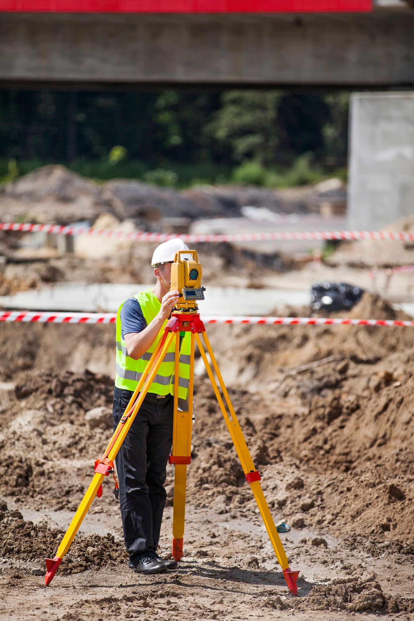 Civil engineer for bridges conducting detailed land surveying for a new bridge project.