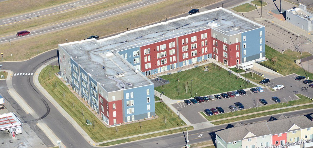 An aerial view of a large apartment building in a residential area