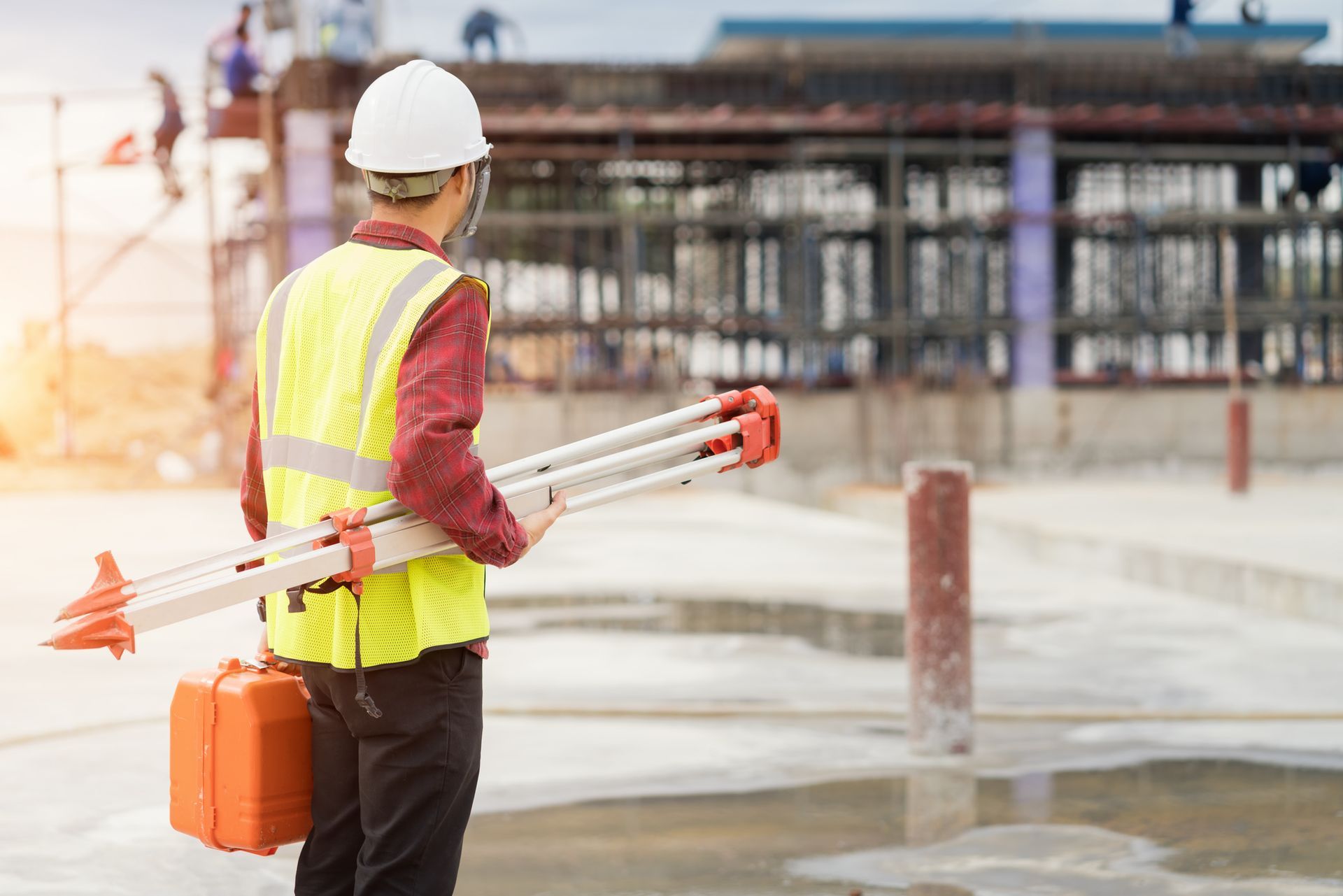 Engineer measuring site levels with survey equipment, promoting expert land surveyors services.