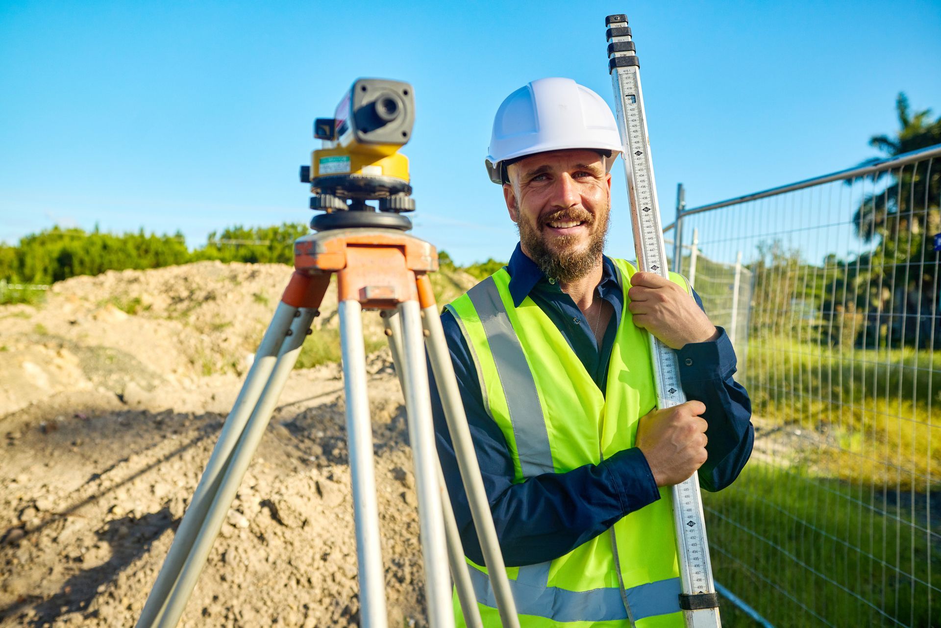 Engineer measuring site levels with survey equipment, promoting expert land surveyors services.