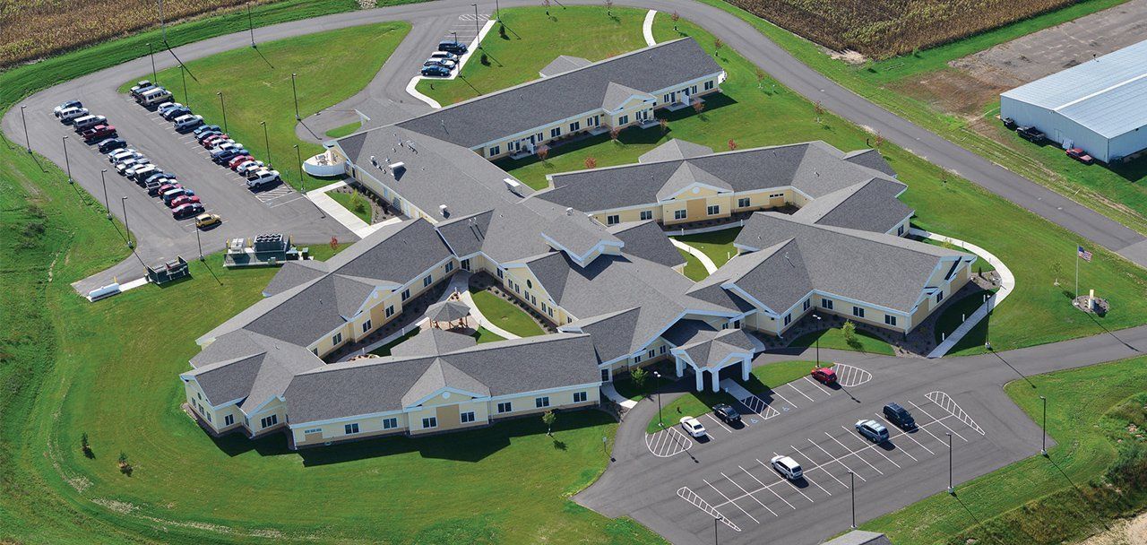 An aerial view of a large building with cars parked in front of it