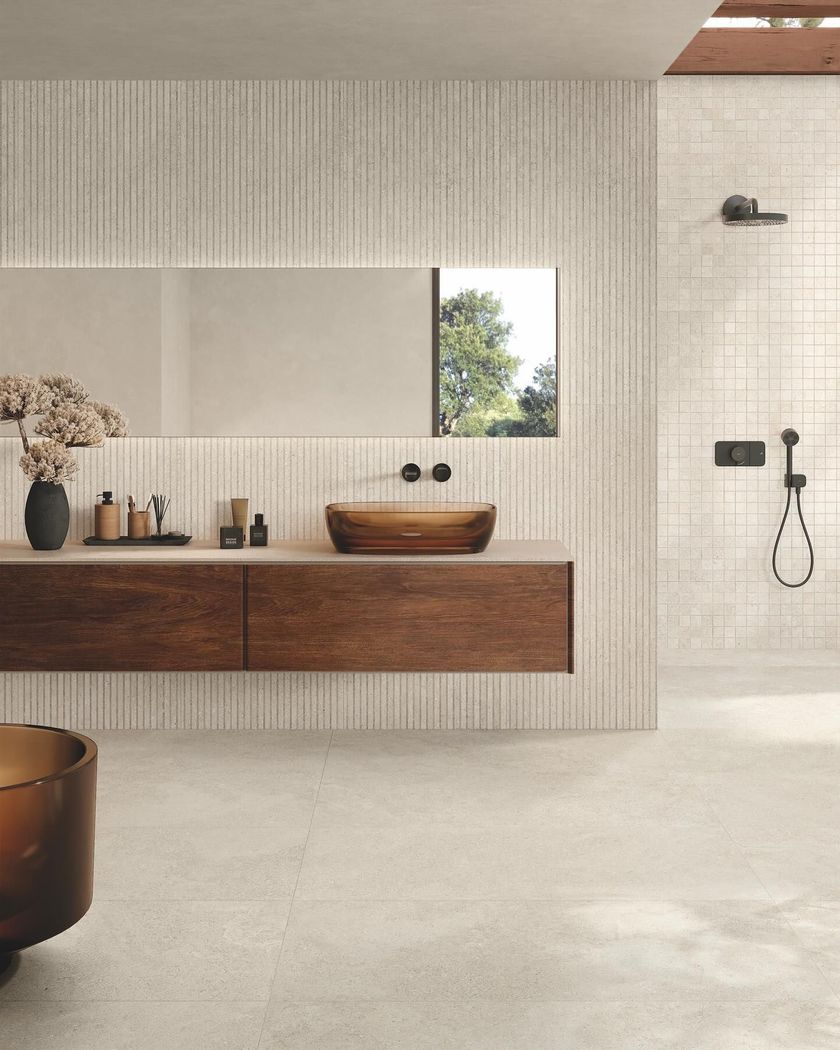 Bagno moderno con mobiletto in legno, lavabo a bacinella, piastrelle a righe verticali alle pareti e zona doccia separata.
