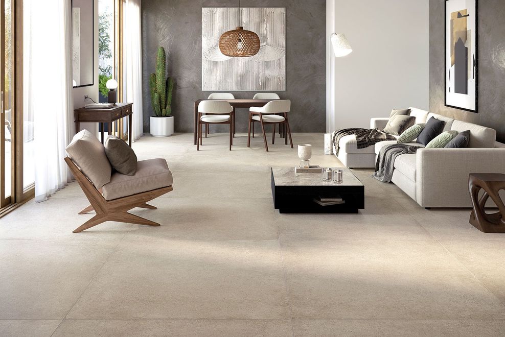Un moderno soggiorno e zona pranzo caratterizzati da un pavimento in pietra chiara, mobili dai colori neutri e un arredamento minimalista.