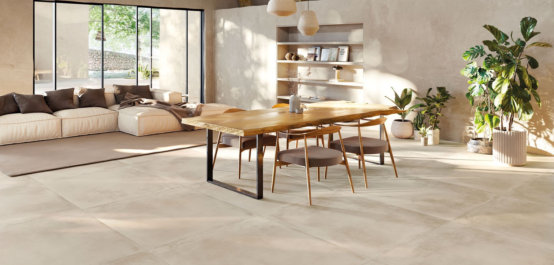 Un luminoso e moderno soggiorno a pianta aperta con pavimento in piastrelle chiare, tavolo da pranzo e divano componibile vicino a una finestra.