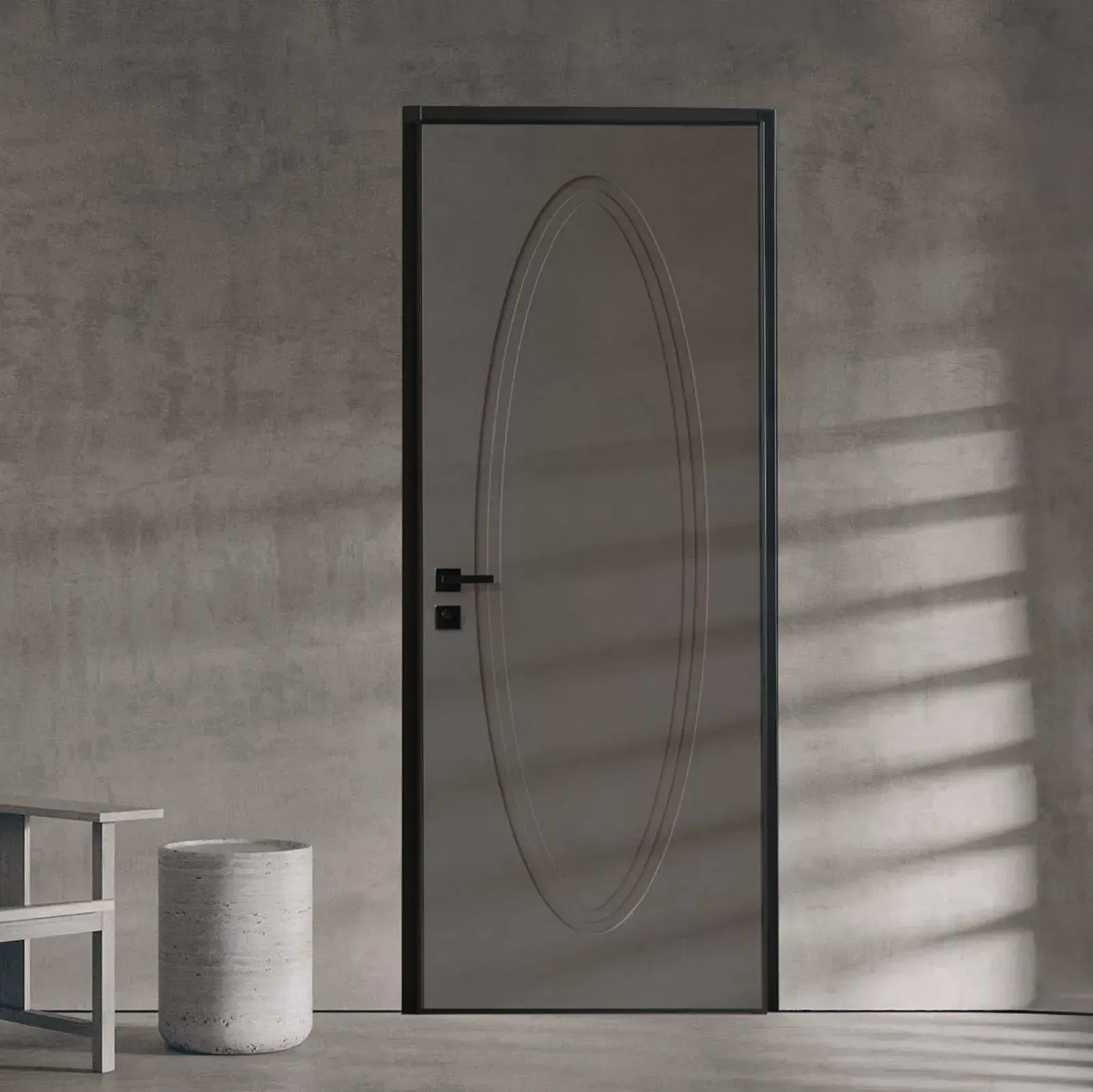 Una moderna porta color tortora con cornice nera e intarsio decorativo ovale, posizionata su una parete grigia con finitura materica.