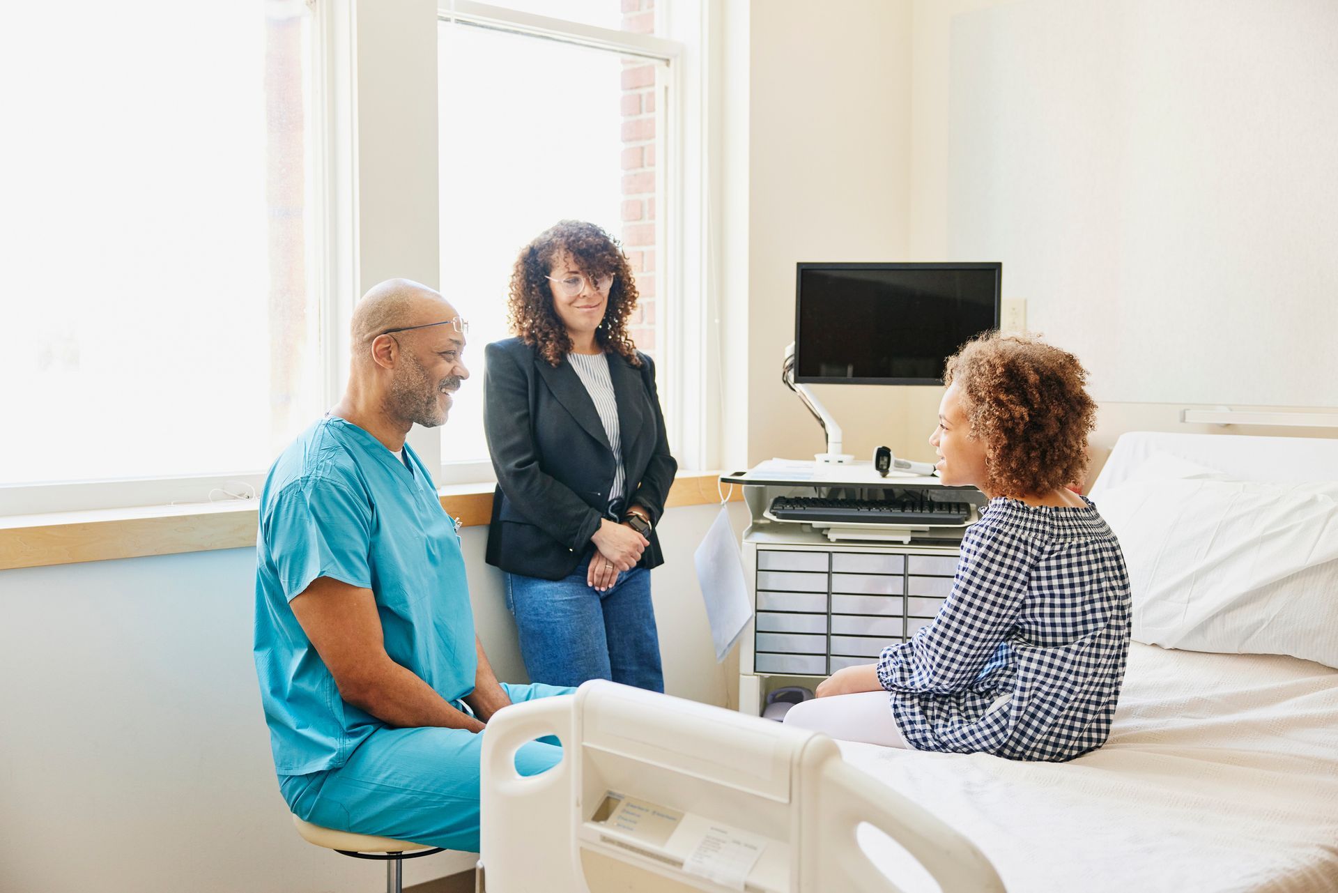 Doctor consulting patient in hospital room at urgent care center for personalized medical attention.