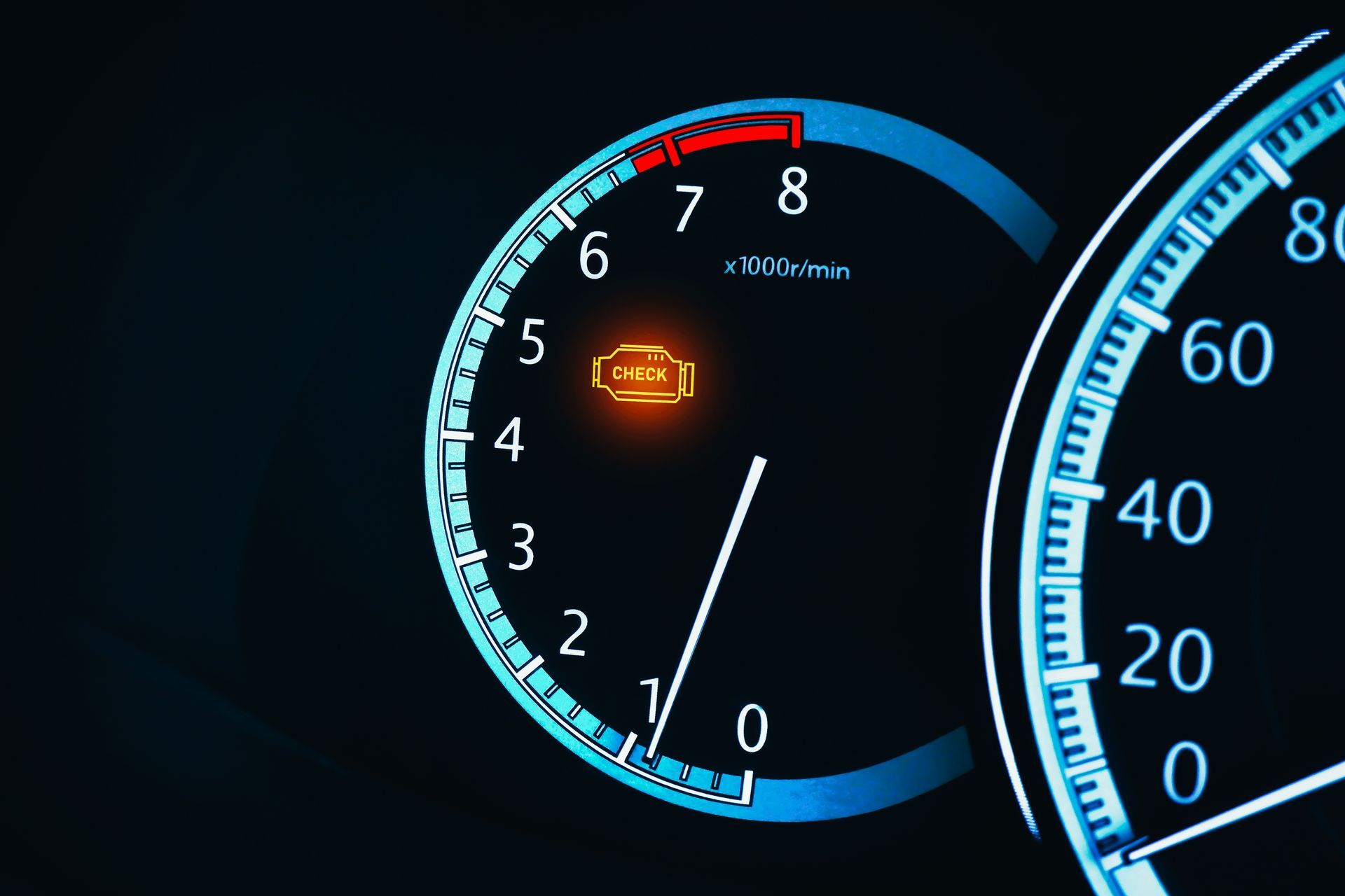 A close up of a car 's speedometer with an orange light on it