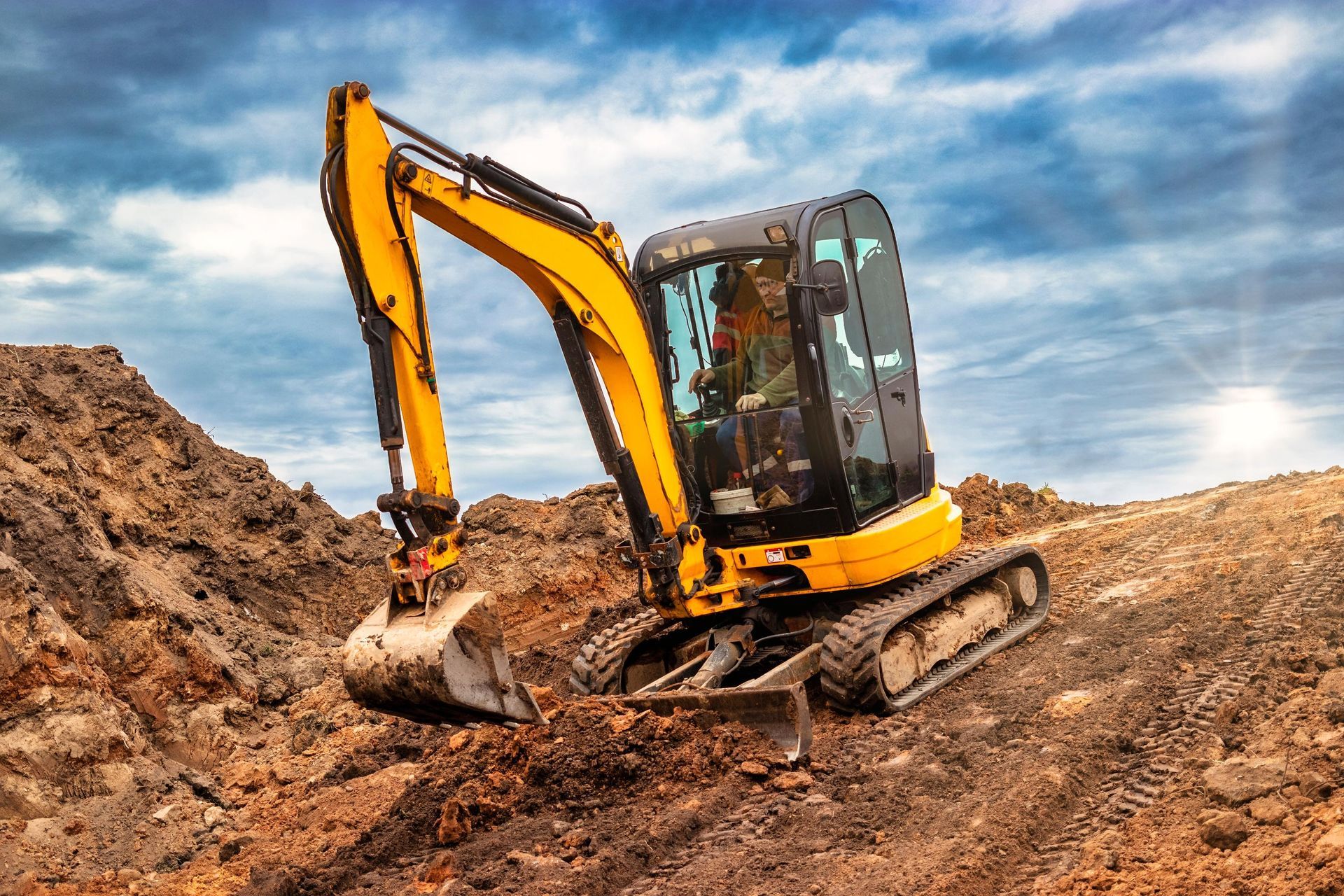 a yellow excavator is digging in the dirt on a construction site .