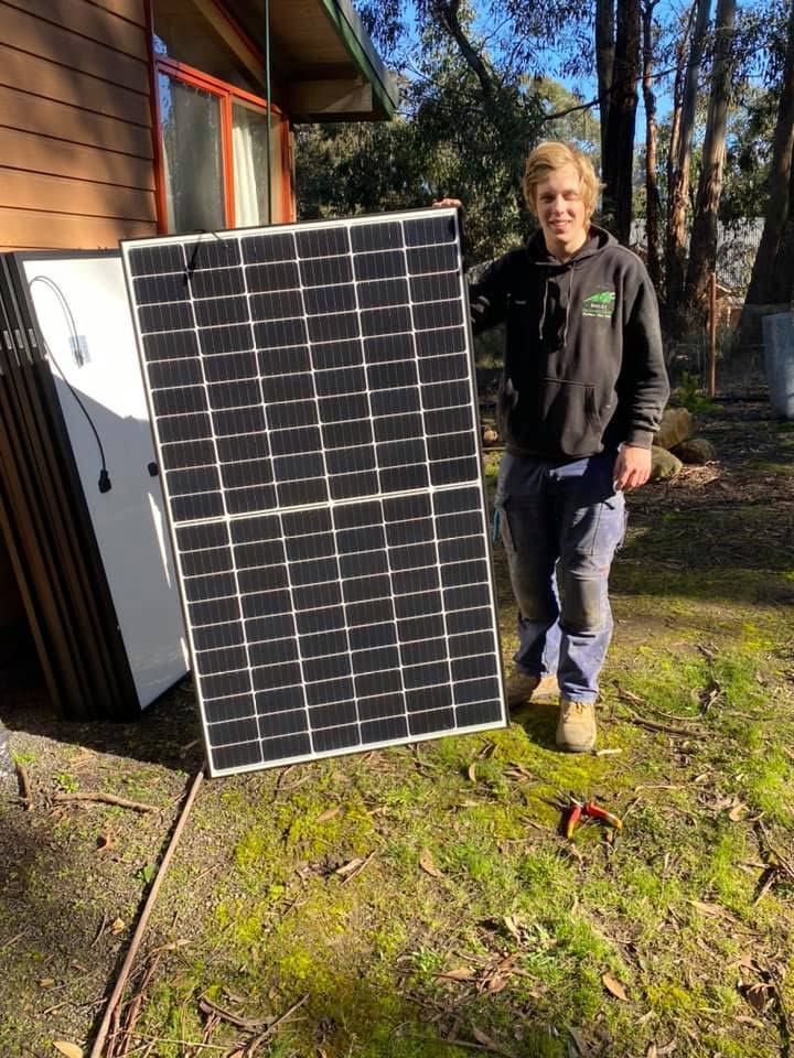 Holding a Large Solar Panel in Front of A House — Off Grid Solar in Lake Gardens VIC