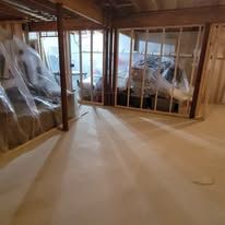 A partially finished interior with wooden framing and tan flooring.