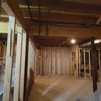 Wooden frame construction, interior basement. Stud walls, exposed ceiling beams.