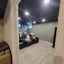 Interior of a home theater with seating, gray walls, and a dark ceiling.