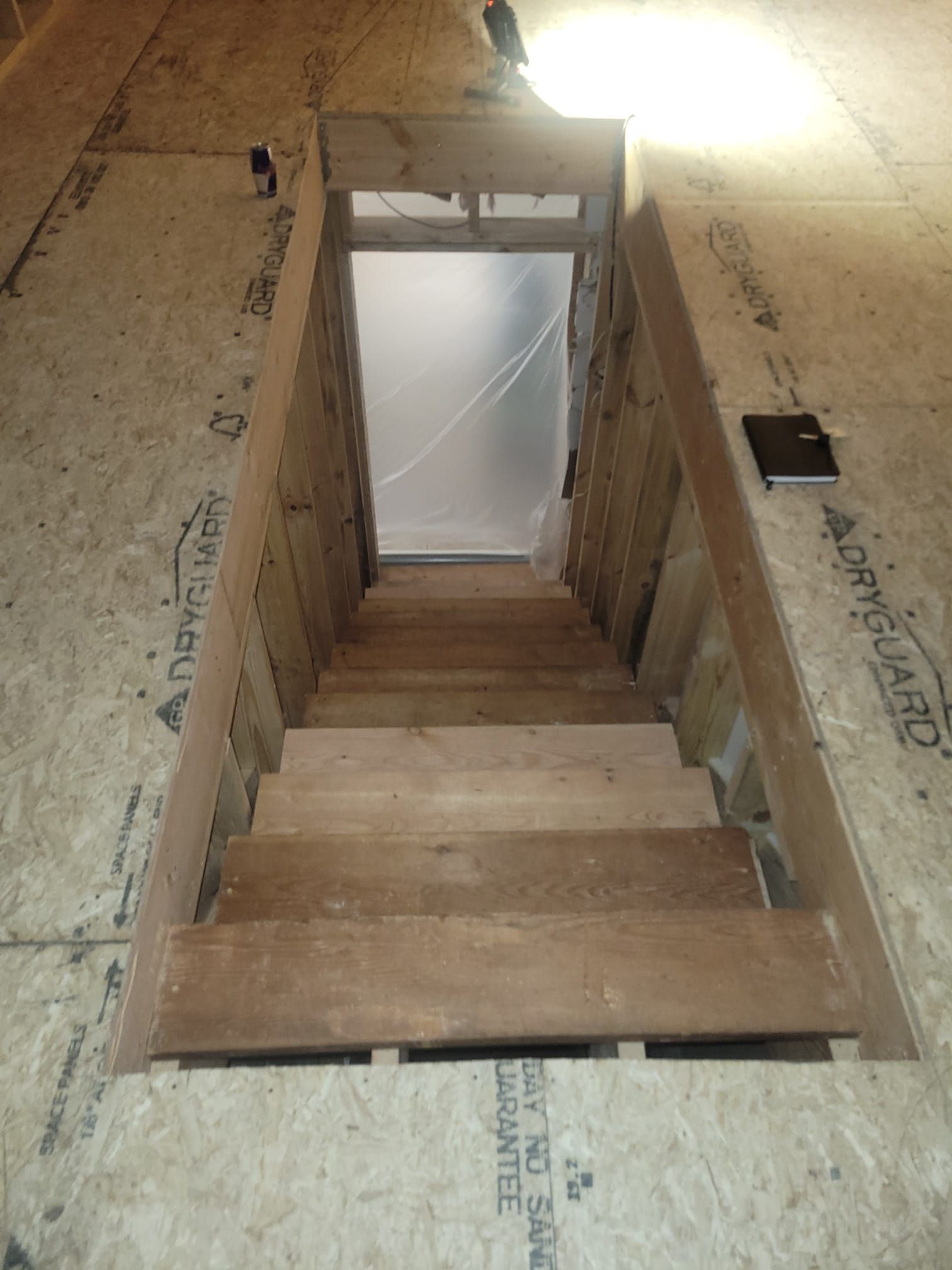 Staircase leading down. Wooden steps and walls. Opening at the top.