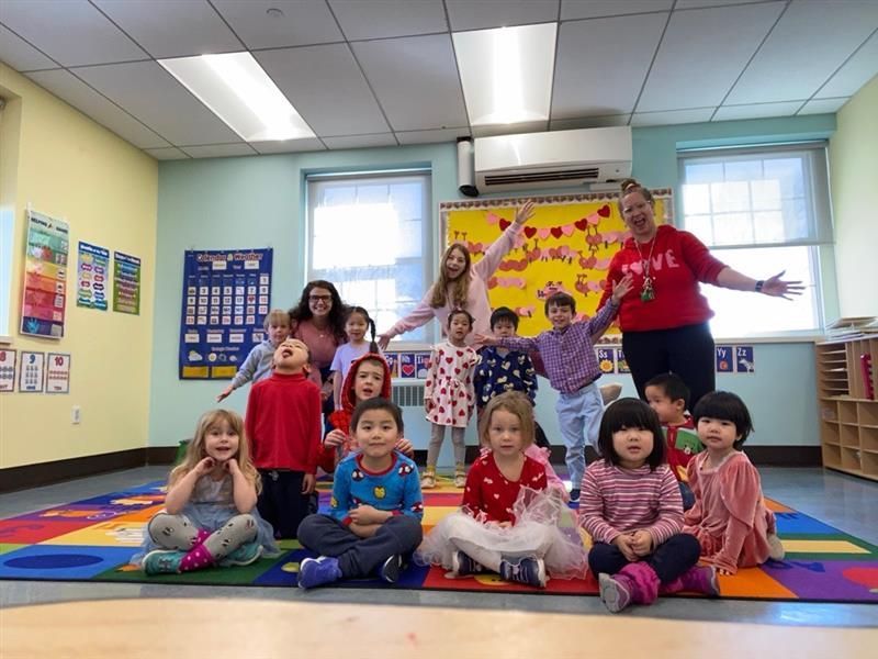 A group of children are posing for a picture in a classroom.