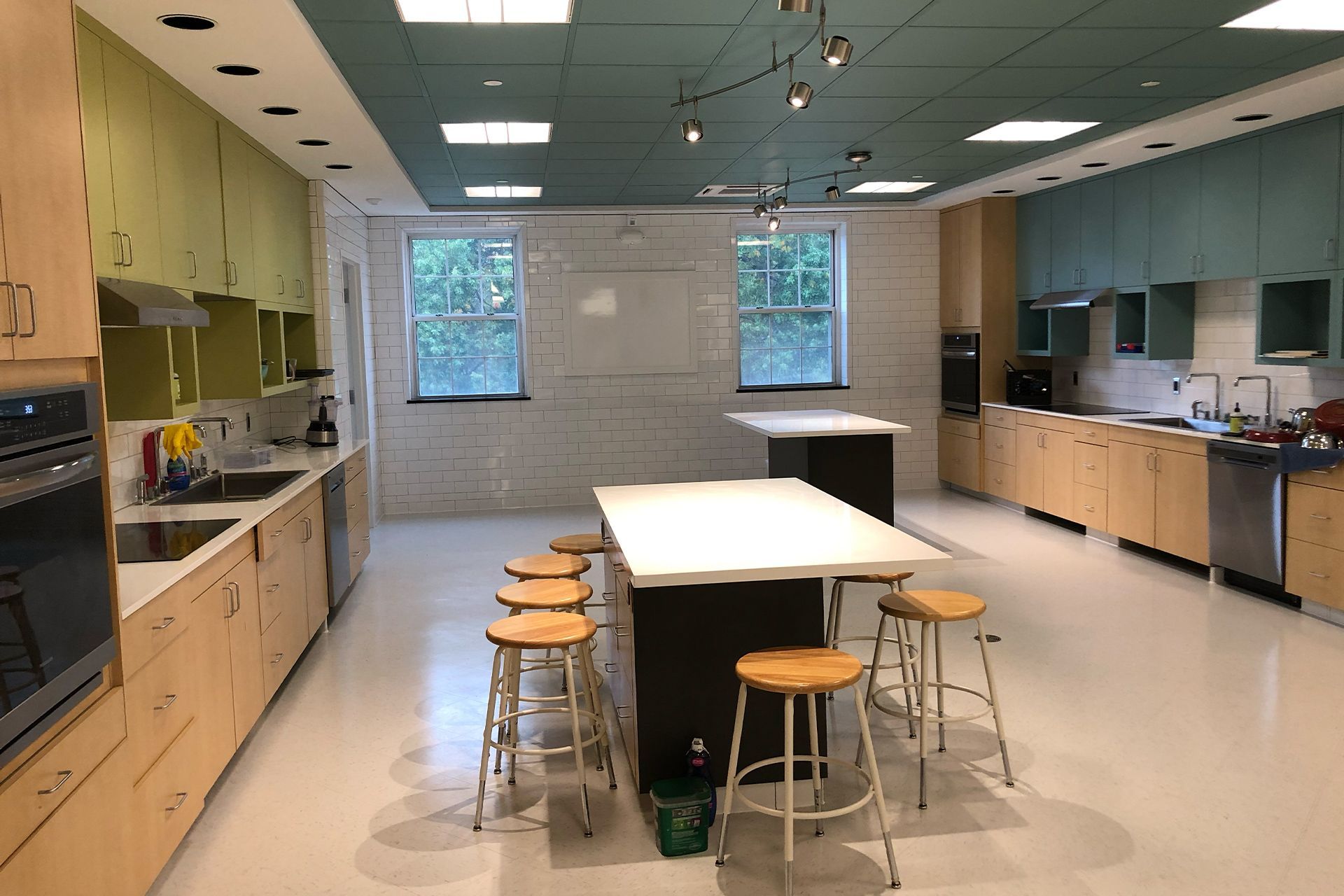 A large kitchen with a table and stools in it