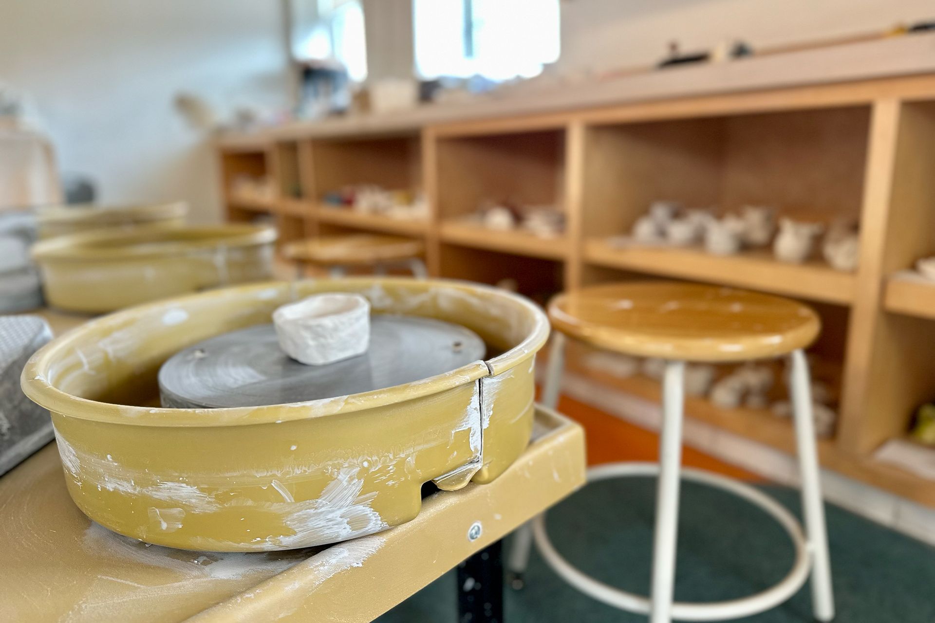 A pottery wheel is sitting on top of a wooden table.