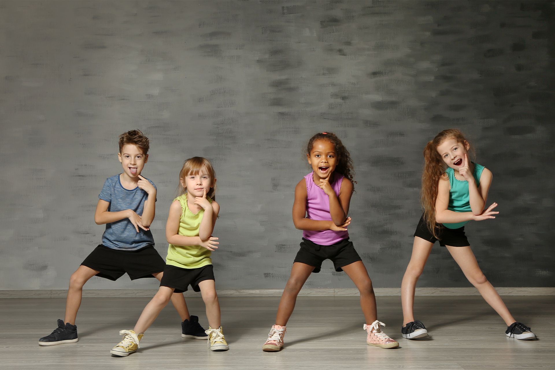 A group of young children are dancing together in a dance studio.