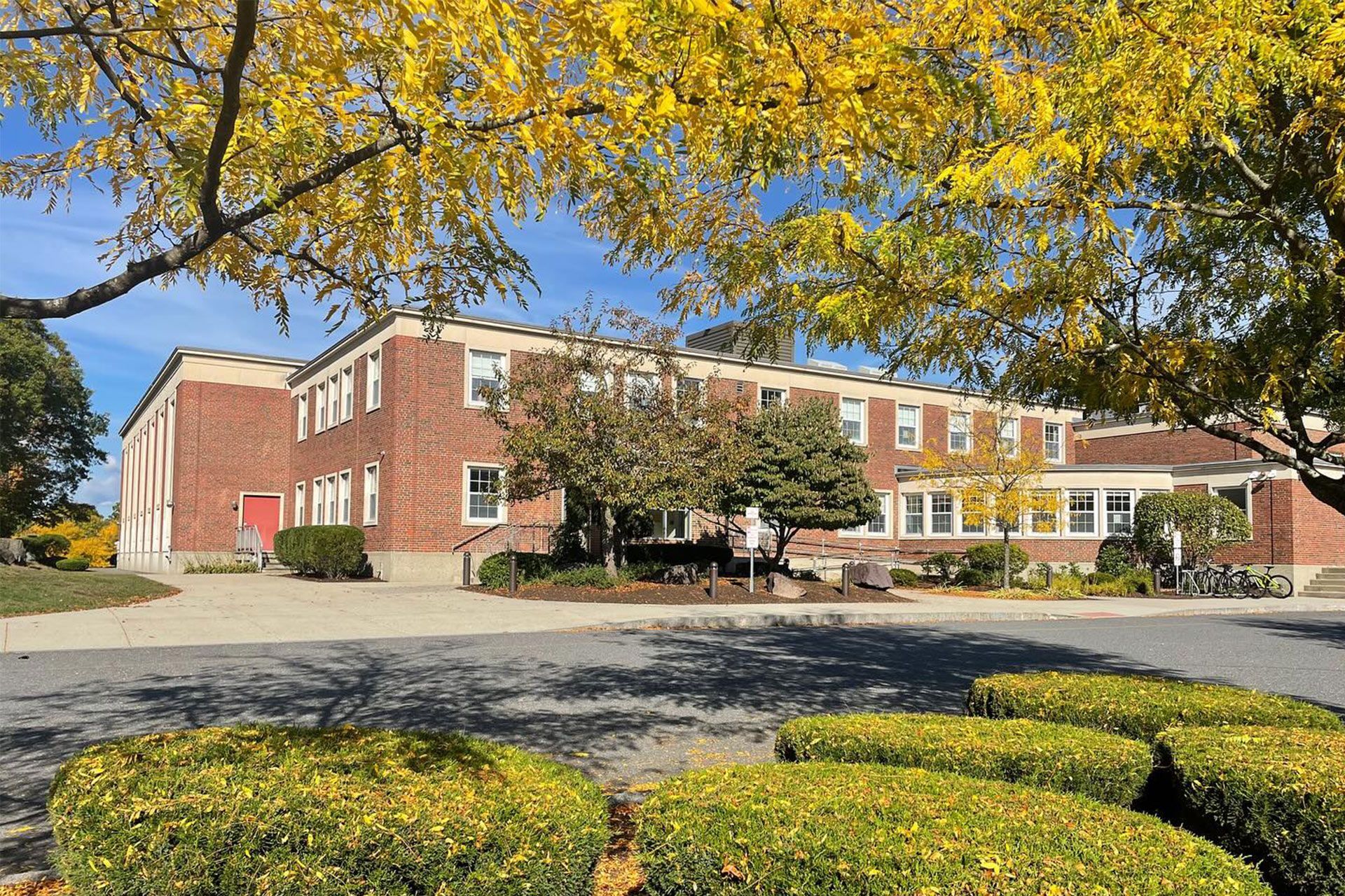 A large brick building with a tree in front of it.