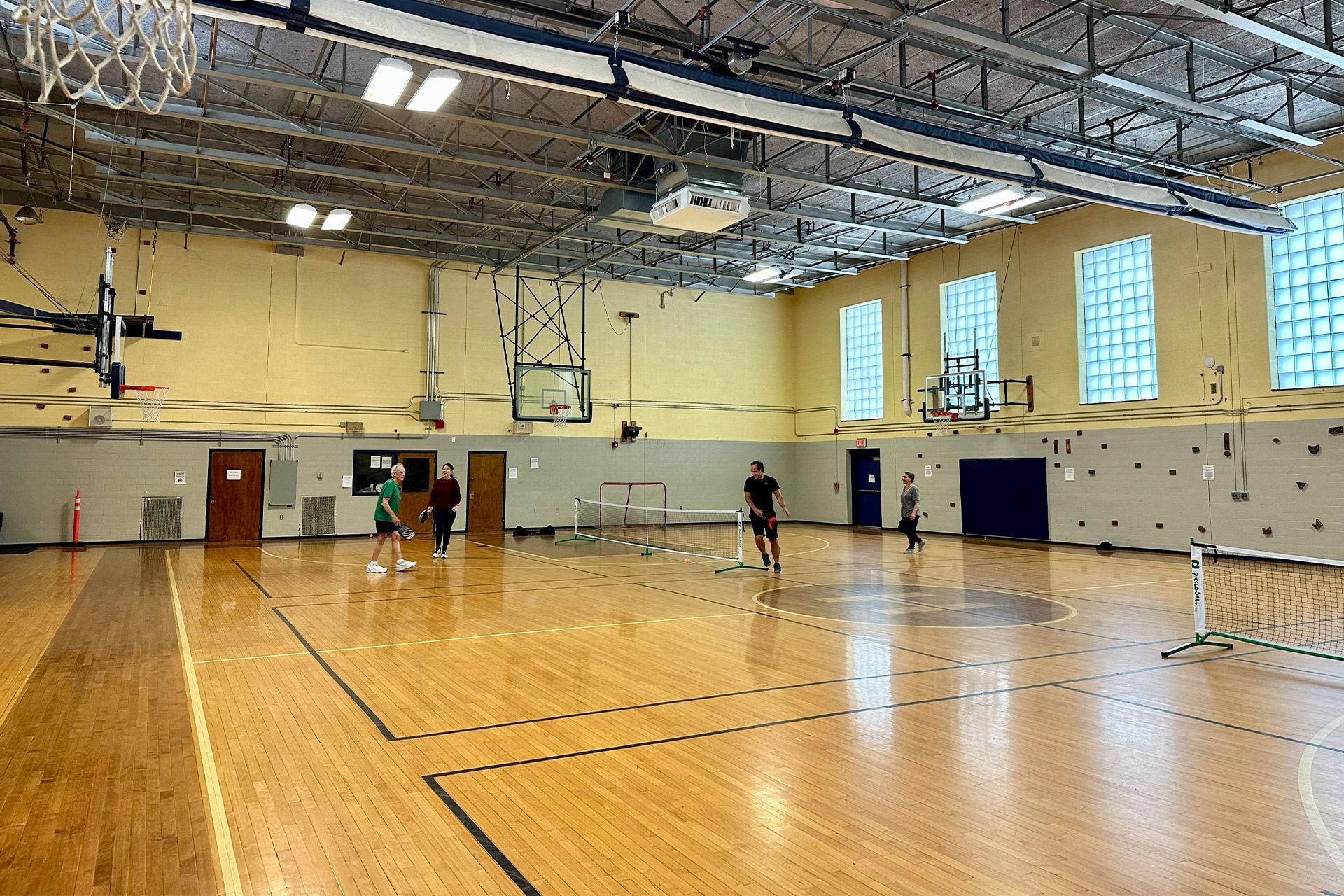A group of people are playing basketball in a gym.
