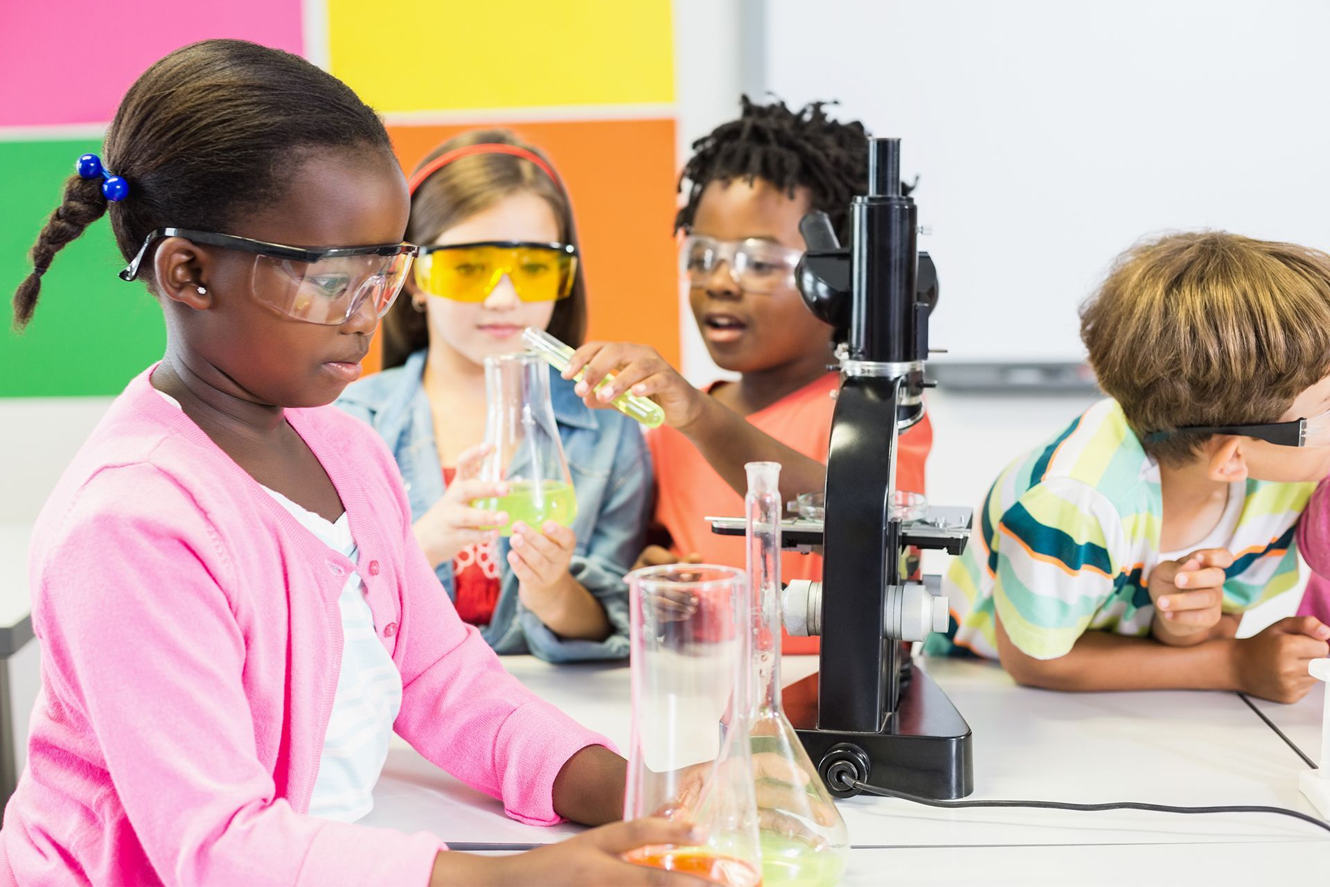 A group of children are doing a science experiment in a classroom.