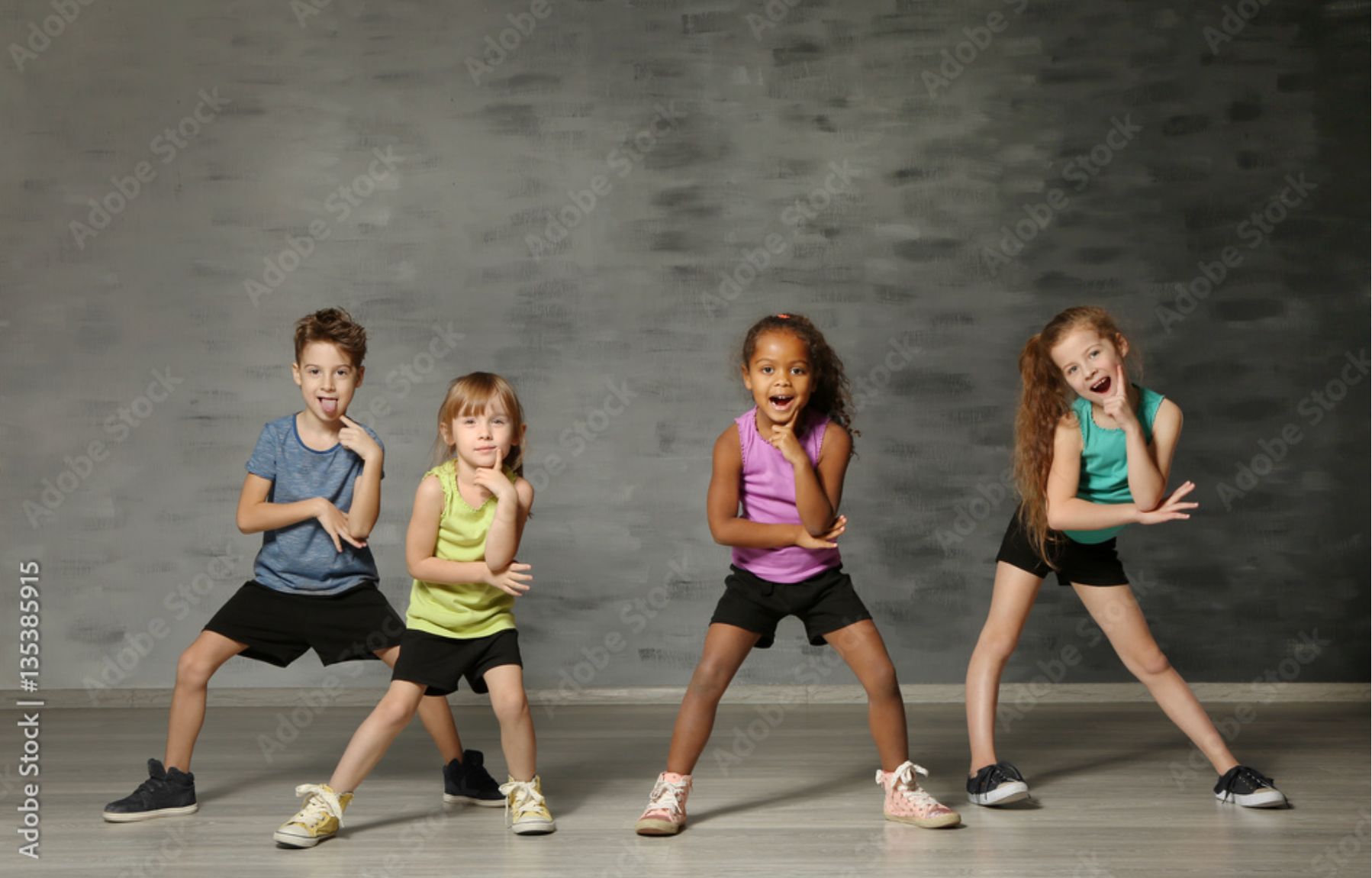A group of young children are dancing together in a dance studio.