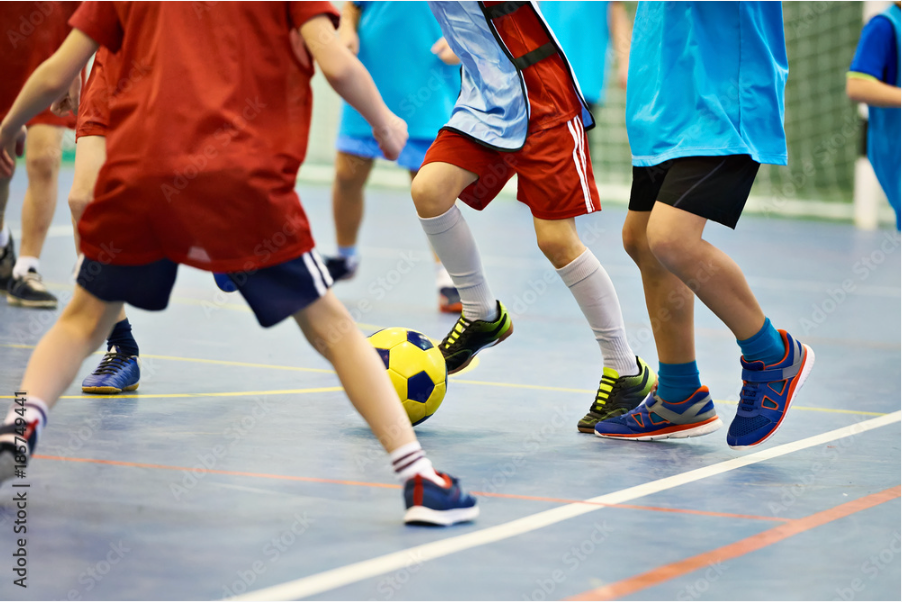 A group of young boys are playing soccer on a court.