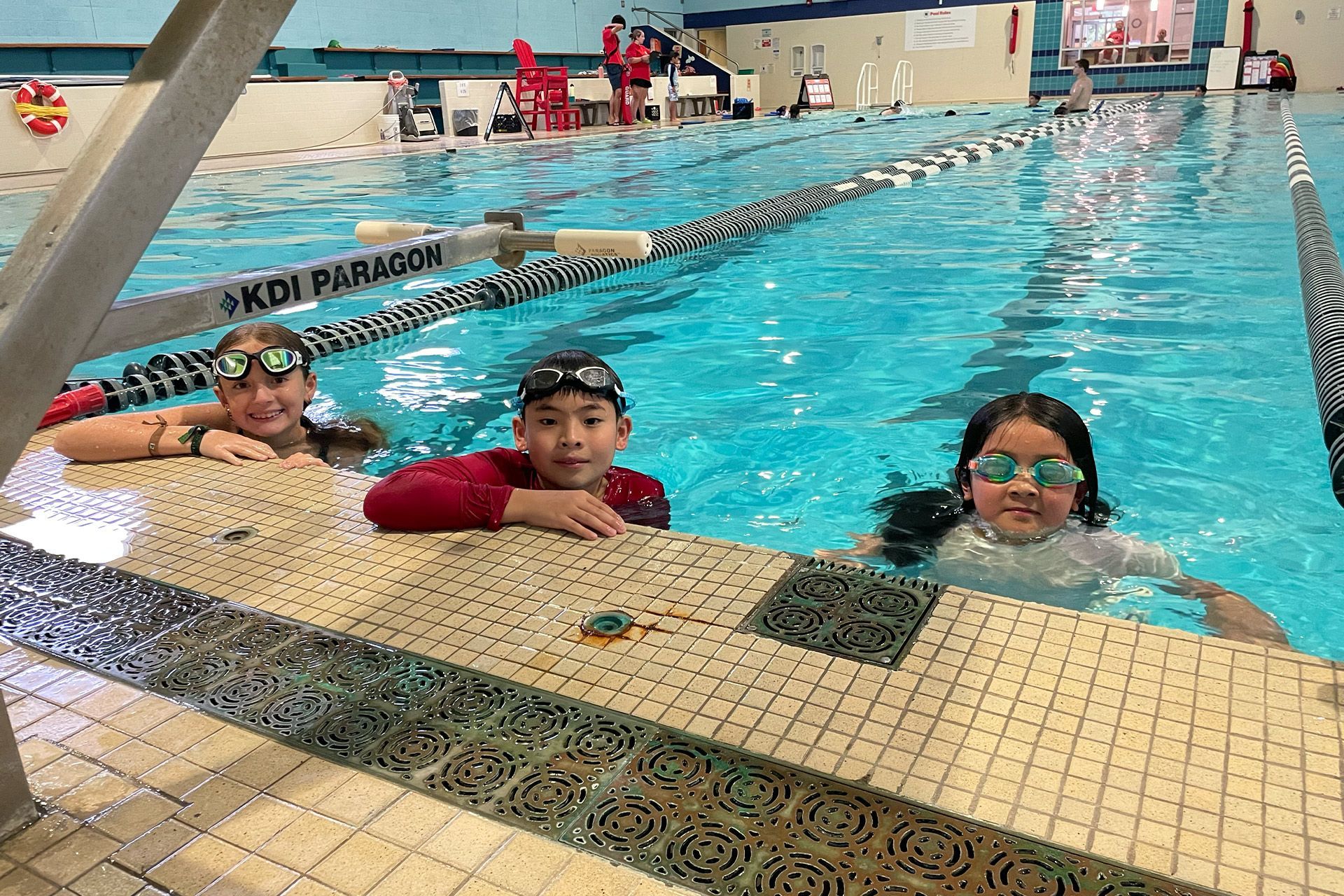 A group of children are swimming in a swimming pool.