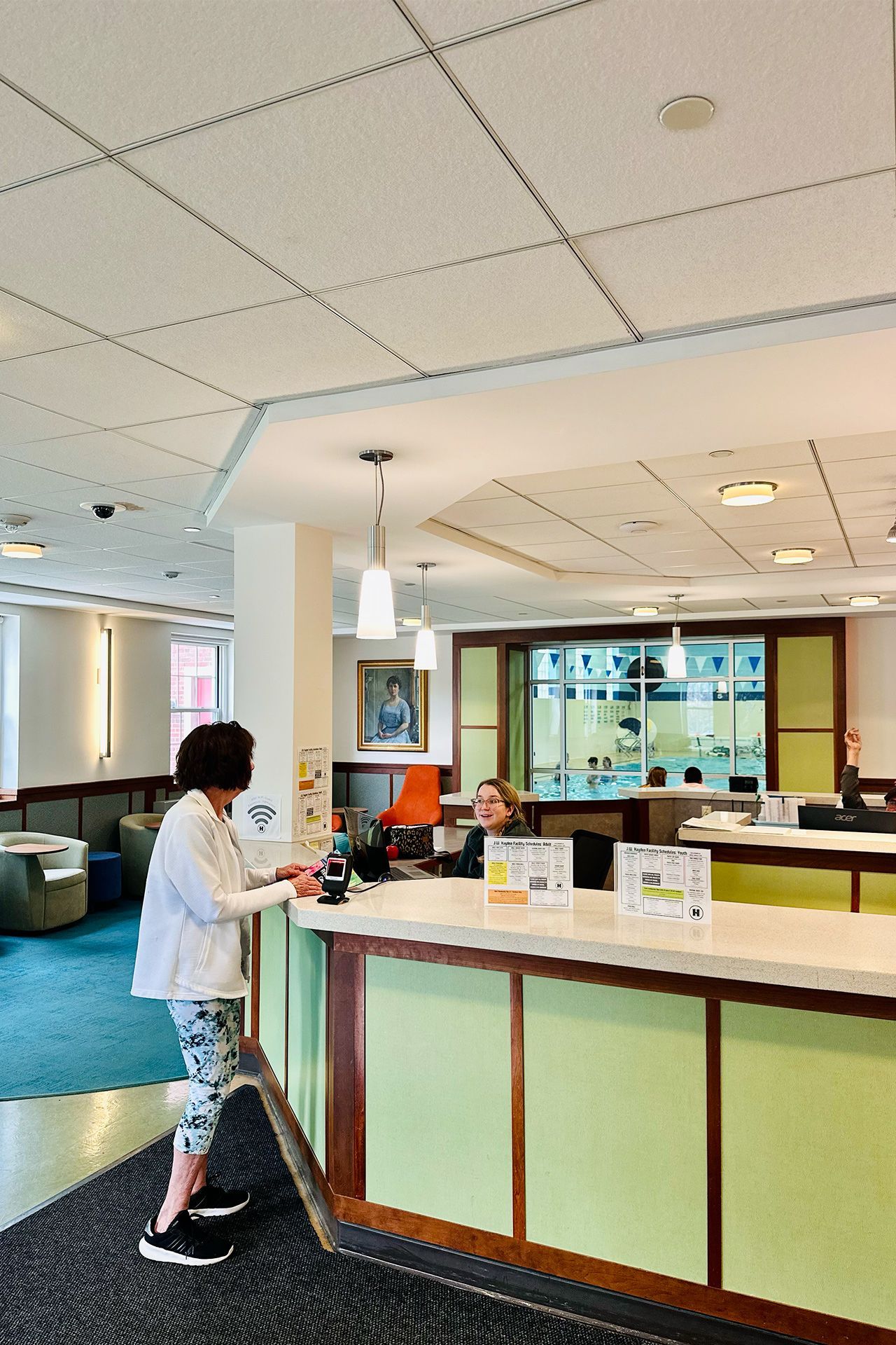 A woman is standing at a counter in a hotel lobby