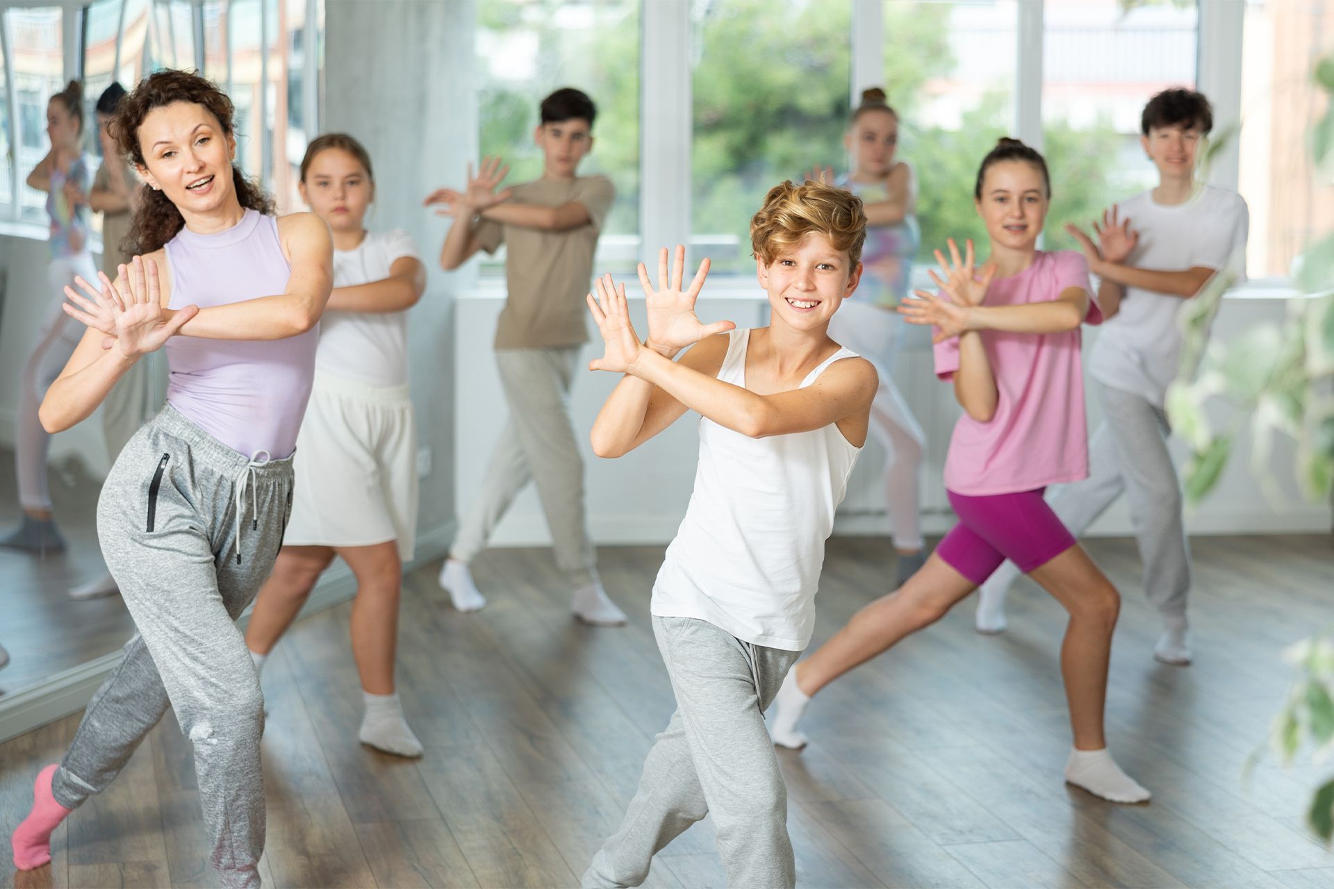 A group of children are dancing in a dance studio.
