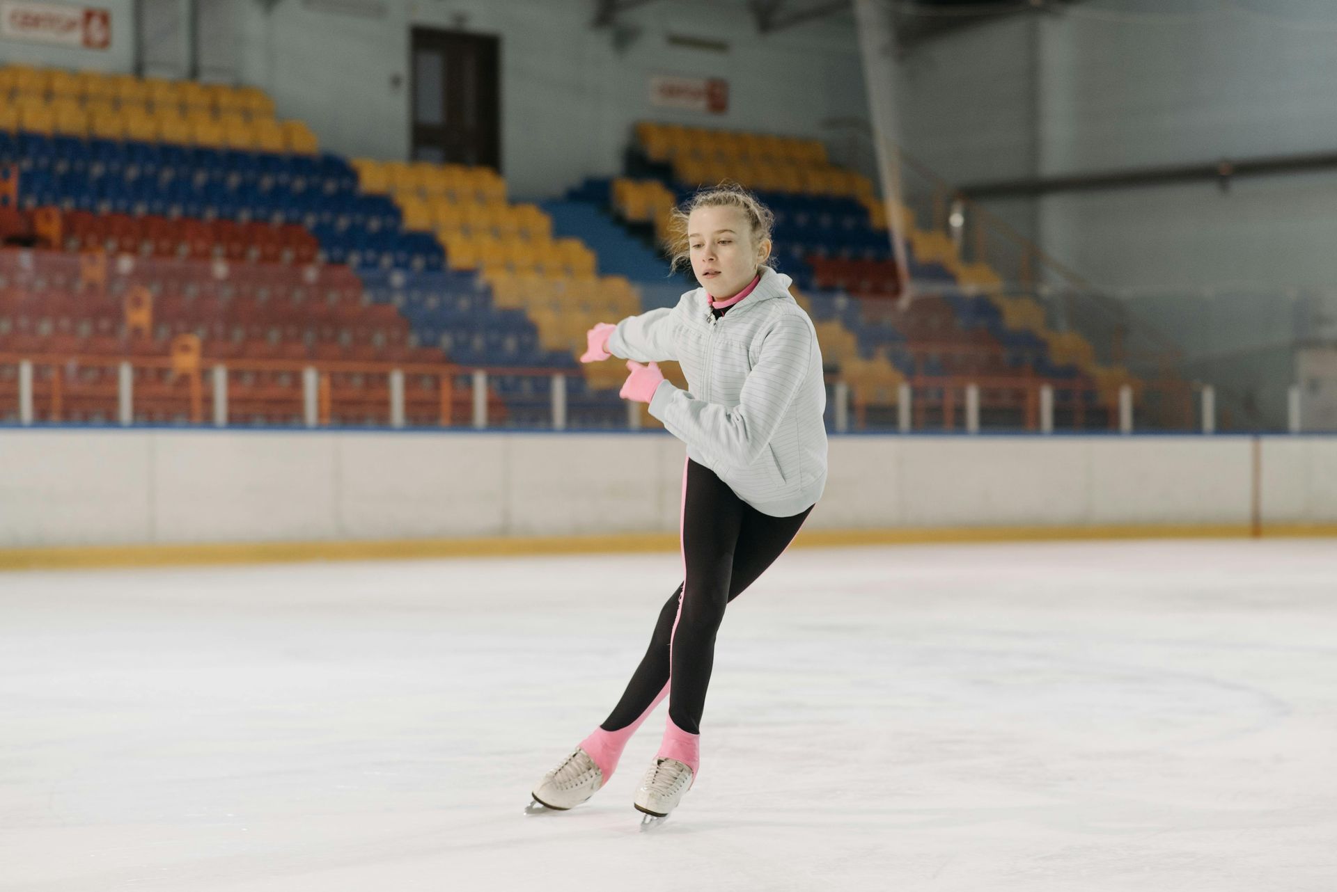 A large indoor ice rink with a fence around it.