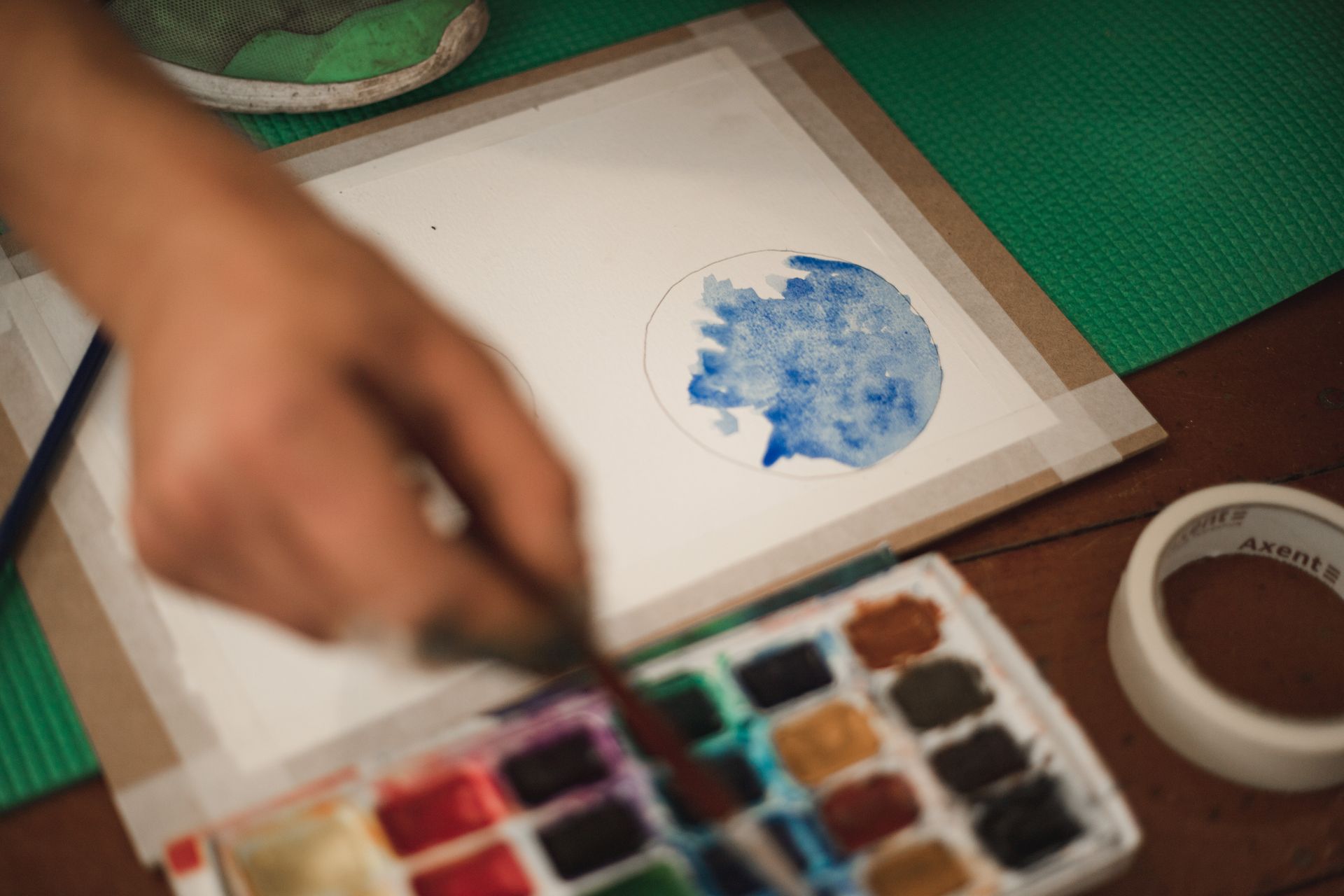 Close-up of colorful drawings scattered on a table; orange and red tones dominate.