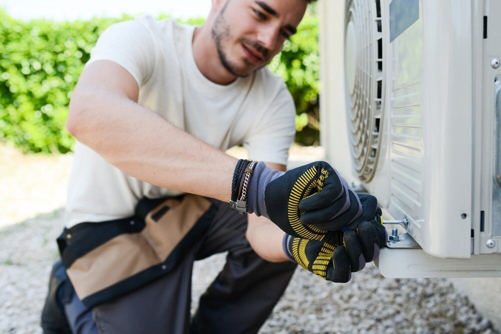 Man Fixing Outdoor Aircon — Great Northern Airconditioning & Mechanical Services in Pinelands, NT