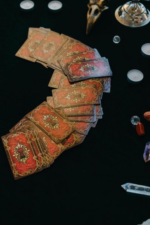 A Quran on a wooden table beside an ornate lamp, with a warm fire glowing in the background.