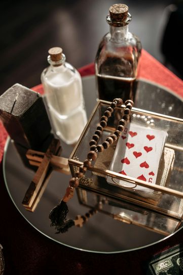 Tray with two small bottles, a wooden abacus, and a playing card decorated with red hearts