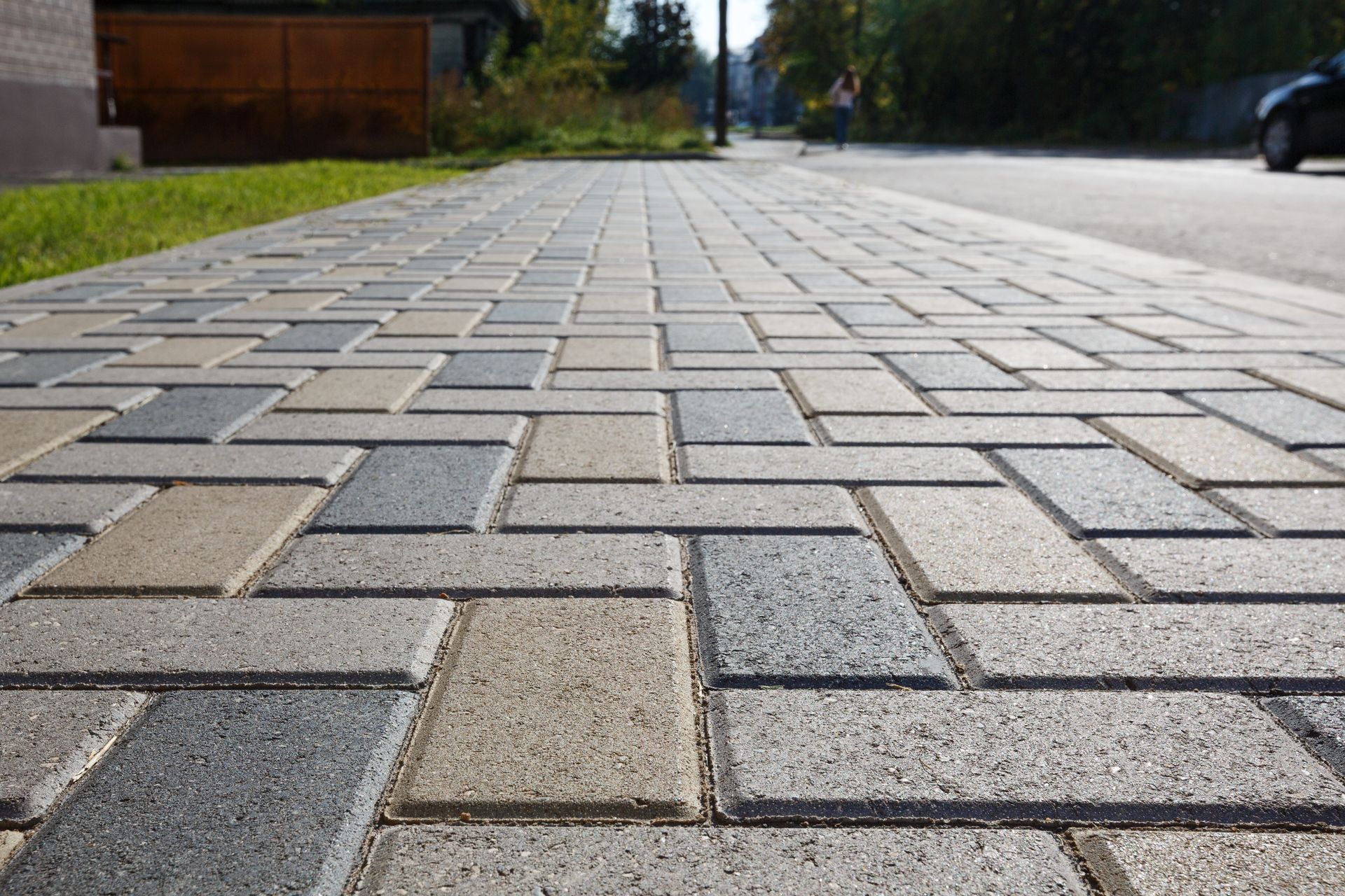 Close-up of a brick sidewalk with a mixed color pattern leading towards a street. Close-up of a brick sidewalk with a mixed color pattern leading towards a street.