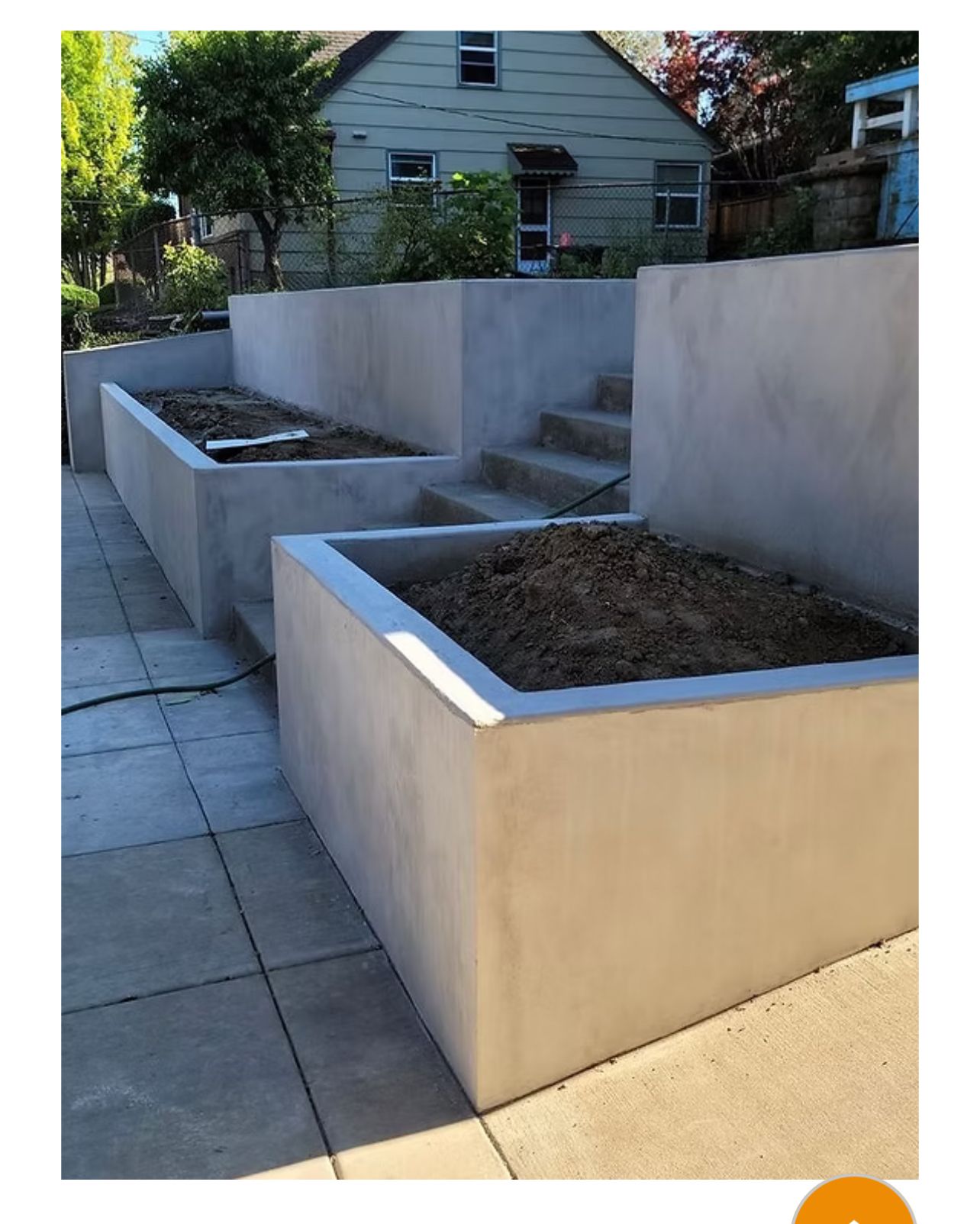 Retaining Wall Made of Dark Stone Blocks Borders — Tucker, GA — A-1 Driveway Replacement Company Retaining Wall Made of Dark Stone Blocks Borders — Tucker, GA — A-1 Driveway Replacement Company