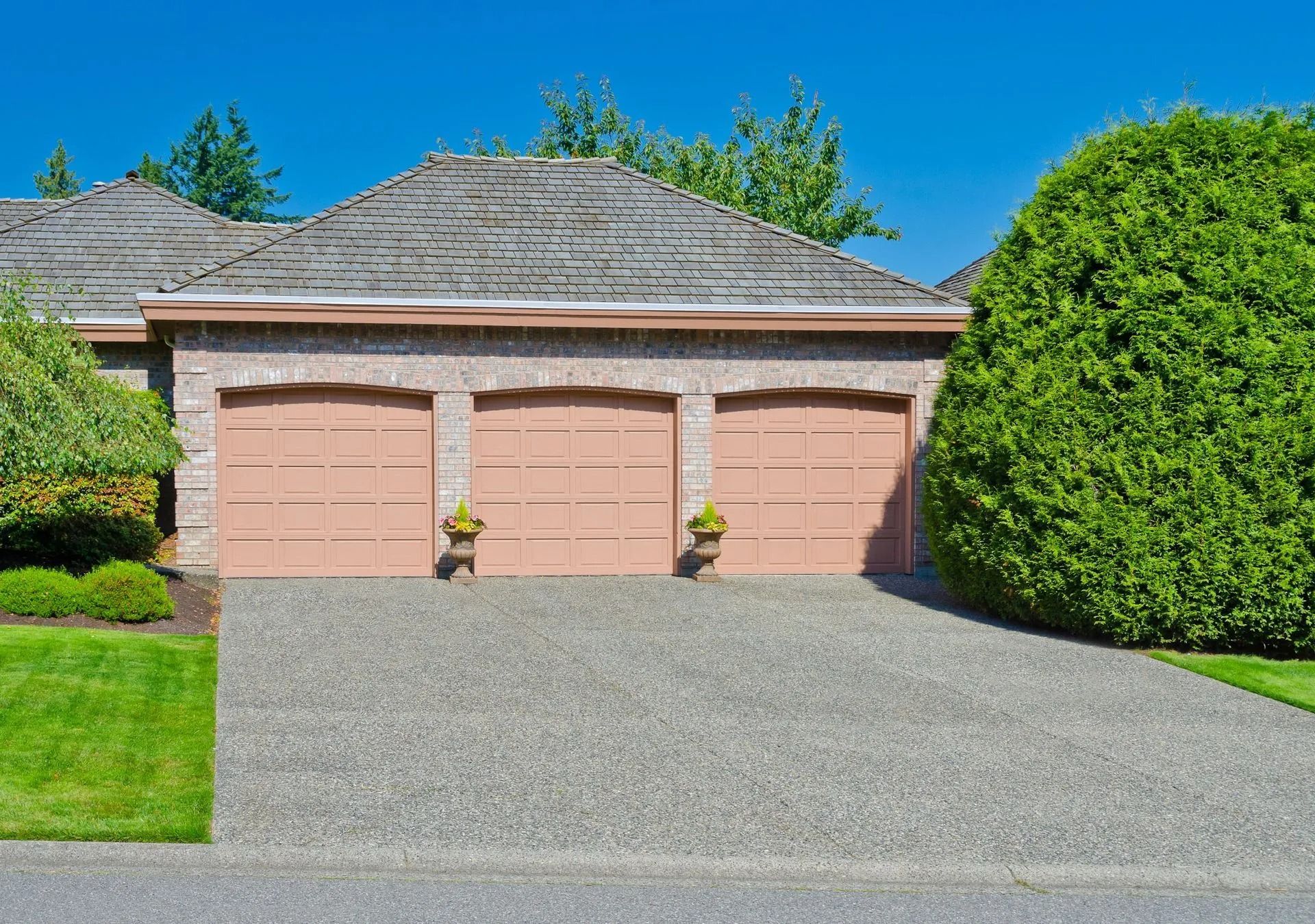 Three-Car Garage with Tan Doors and Gravel Driveway — Tucker, GA — A-1 Driveway Replacement Company