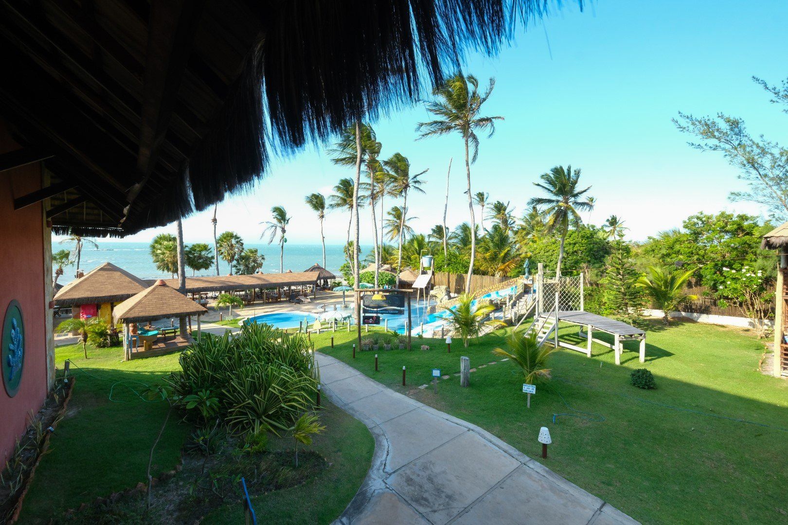 Uma vista de um resort tropical com palmeiras e uma piscina