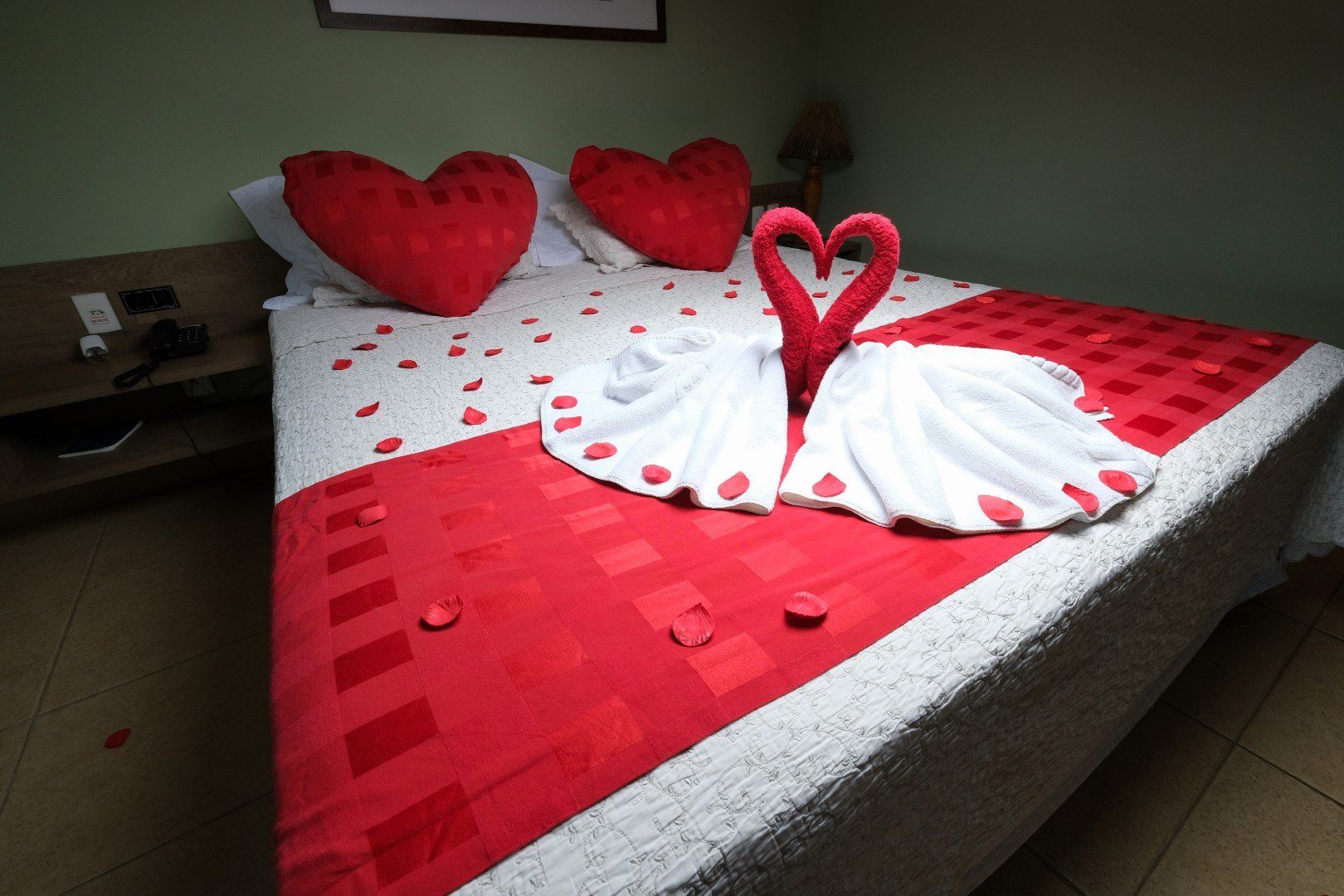 Uma cama decorada para o dia dos namorados com corações e toalhas