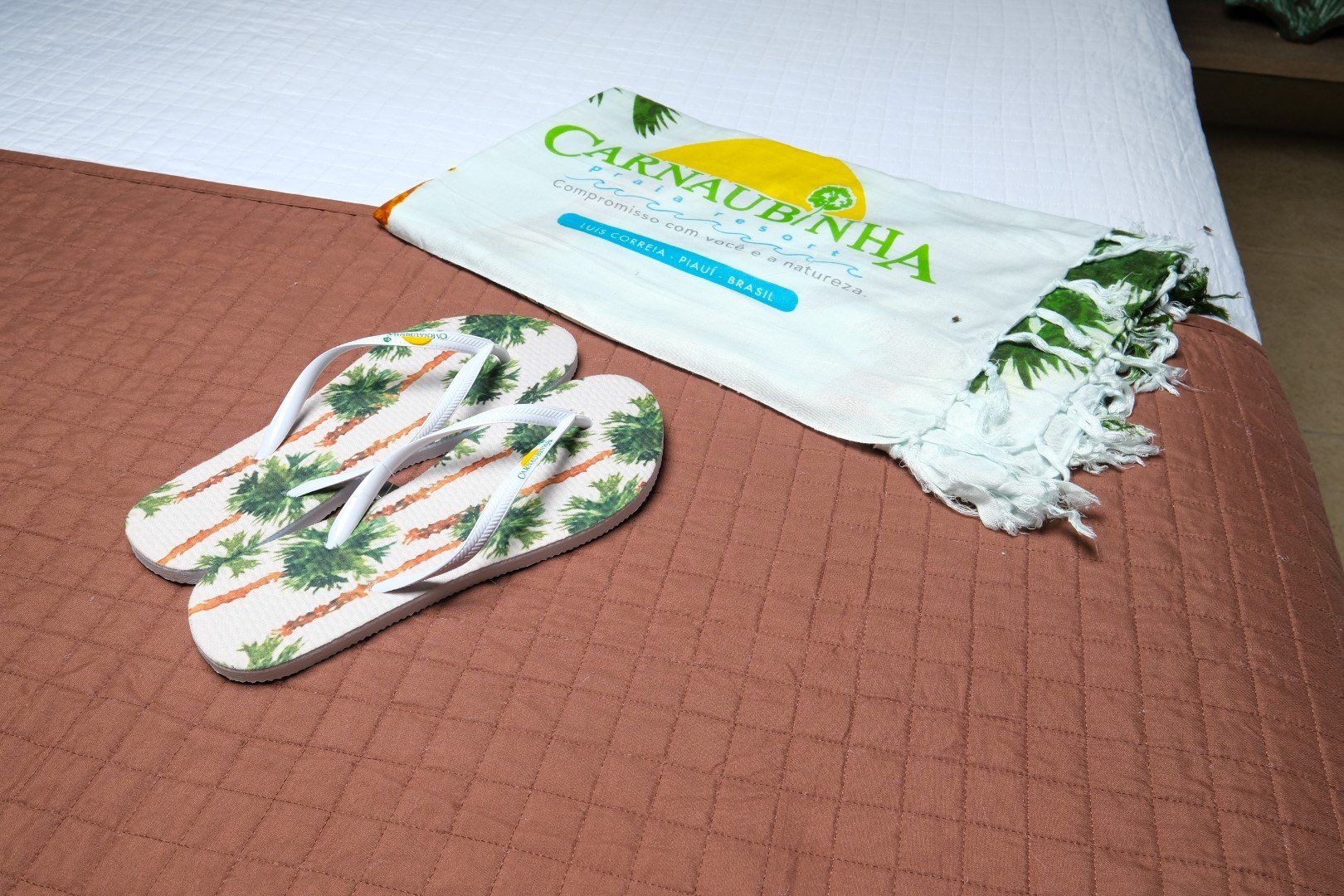 Um par de chinelos e uma toalha em uma cama