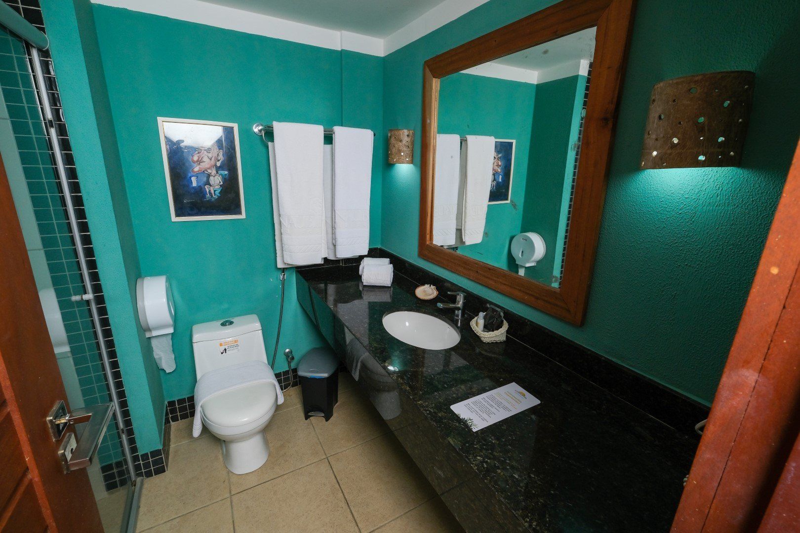 Um banheiro com vaso sanitário, pia e espelho