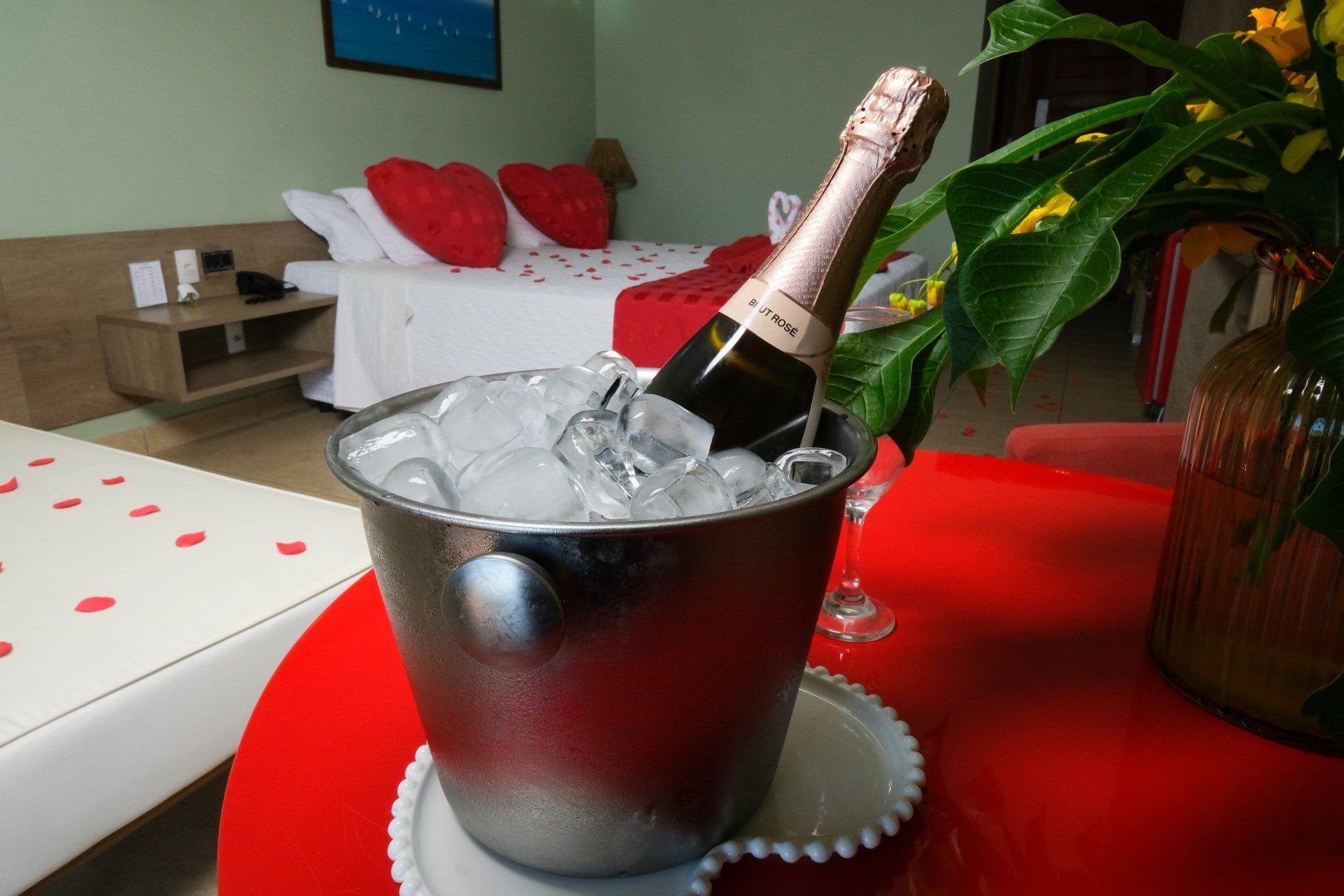 Um balde de gelo e uma garrafa de champanhe em uma mesa em um quarto de hotel.